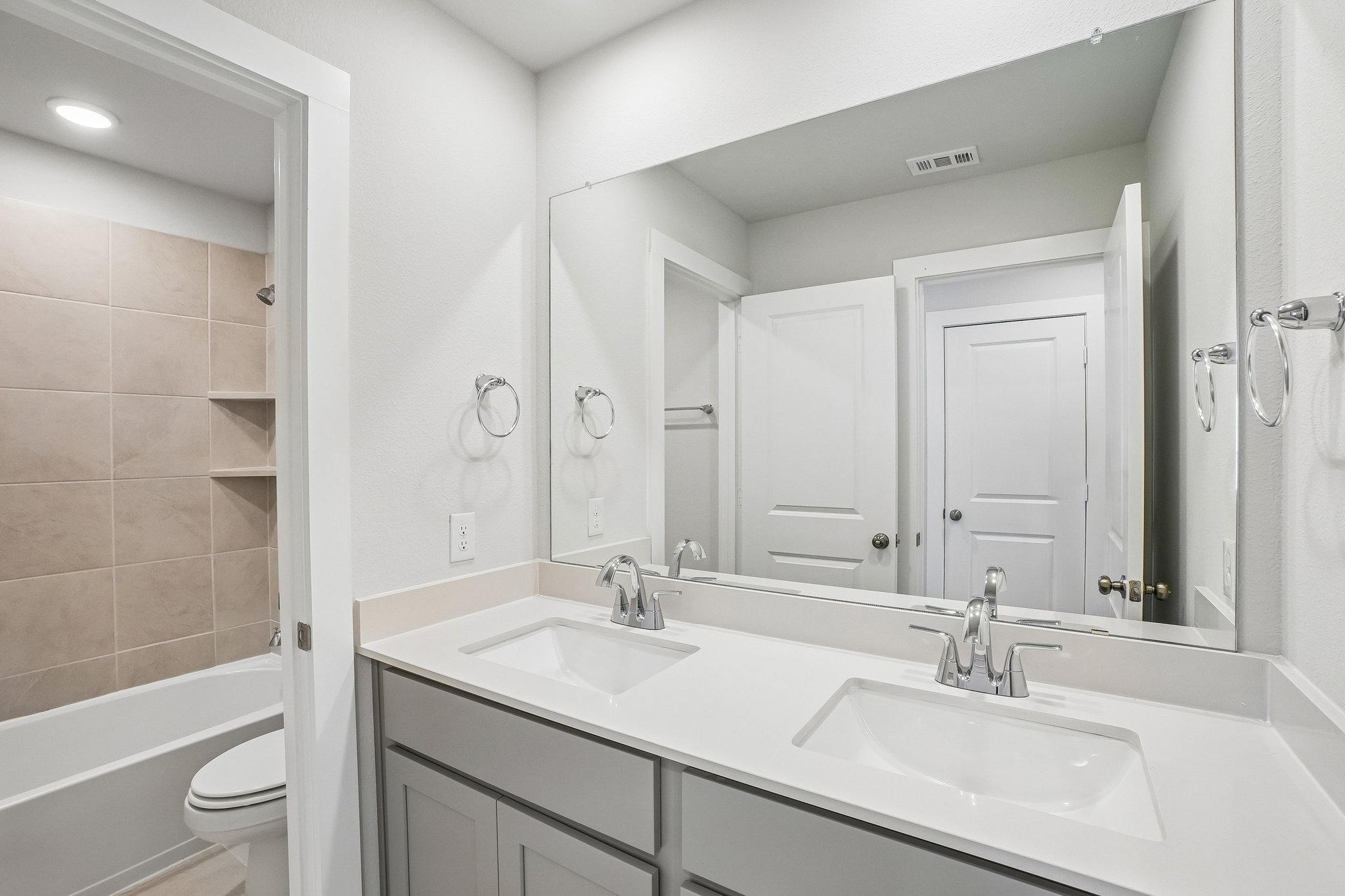 A bathroom with a large mirror.