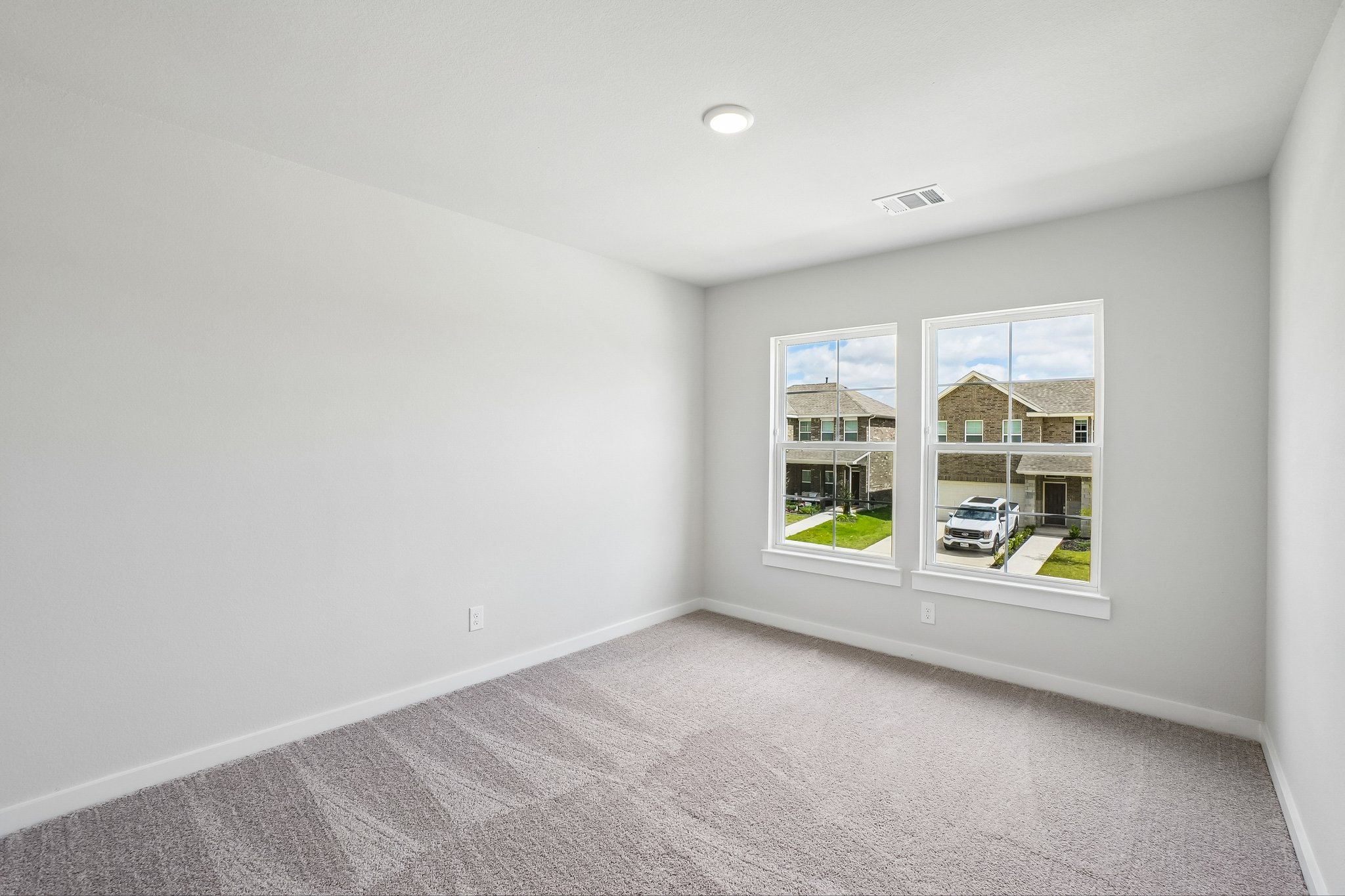 A room with a window and a carpet.