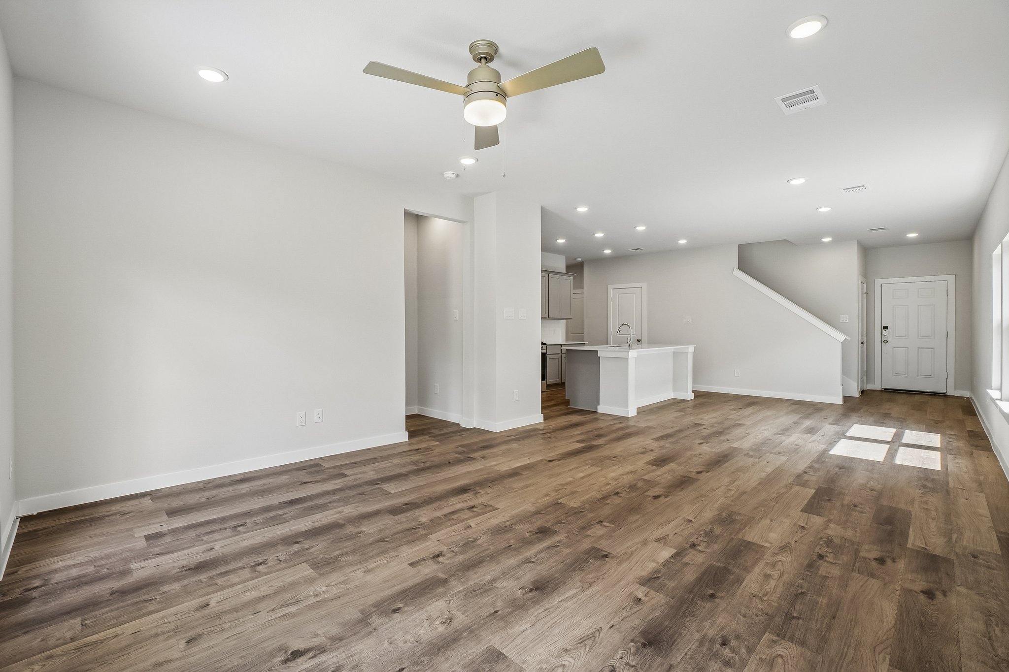 A room with a wood floor and a ceiling fan.
