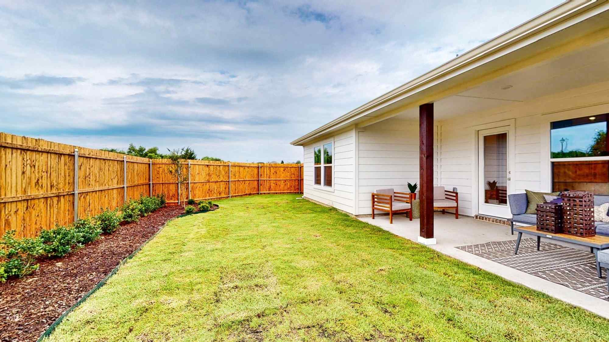 A house with a fence and lawn.