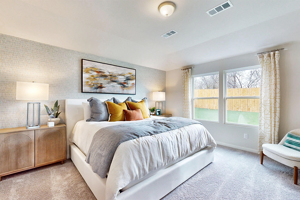 A bedroom with a bed and lamps.