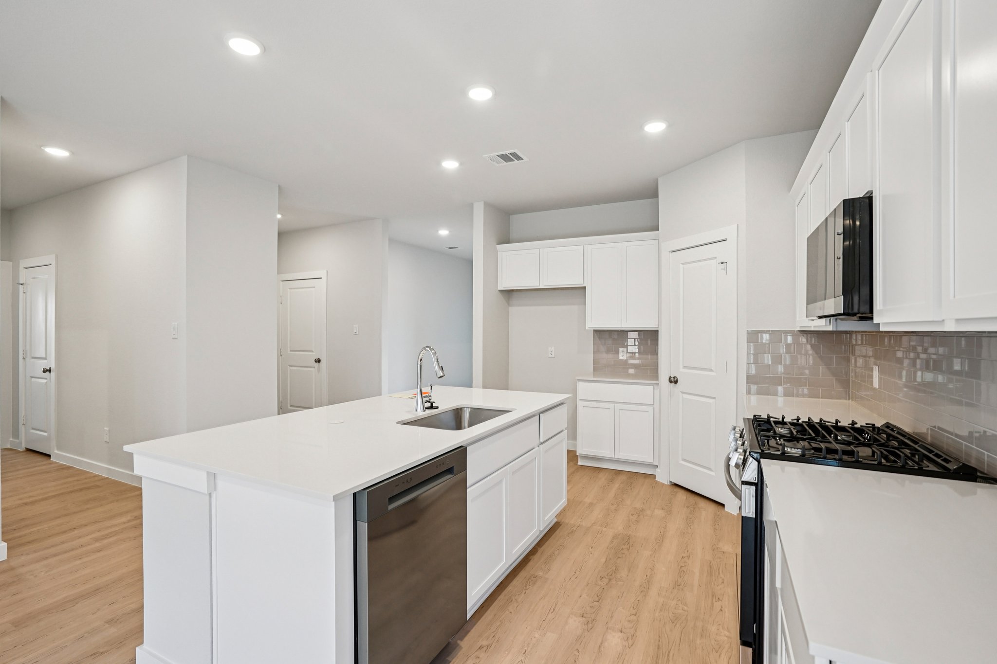 A kitchen with white cabinets.
