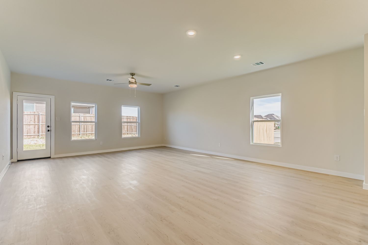 A room with a wood floor and a ceiling fan.