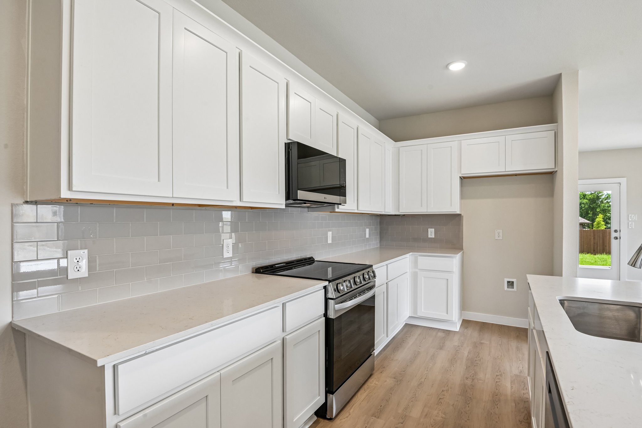 A kitchen with white cabinets.