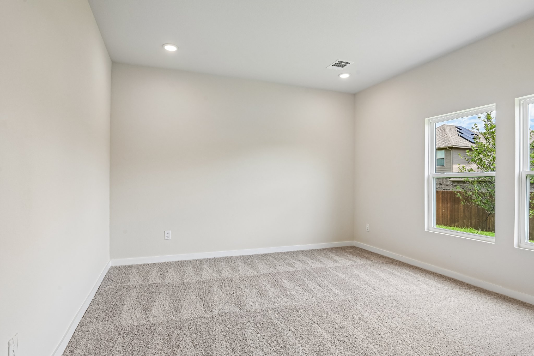 A room with a carpet and windows.