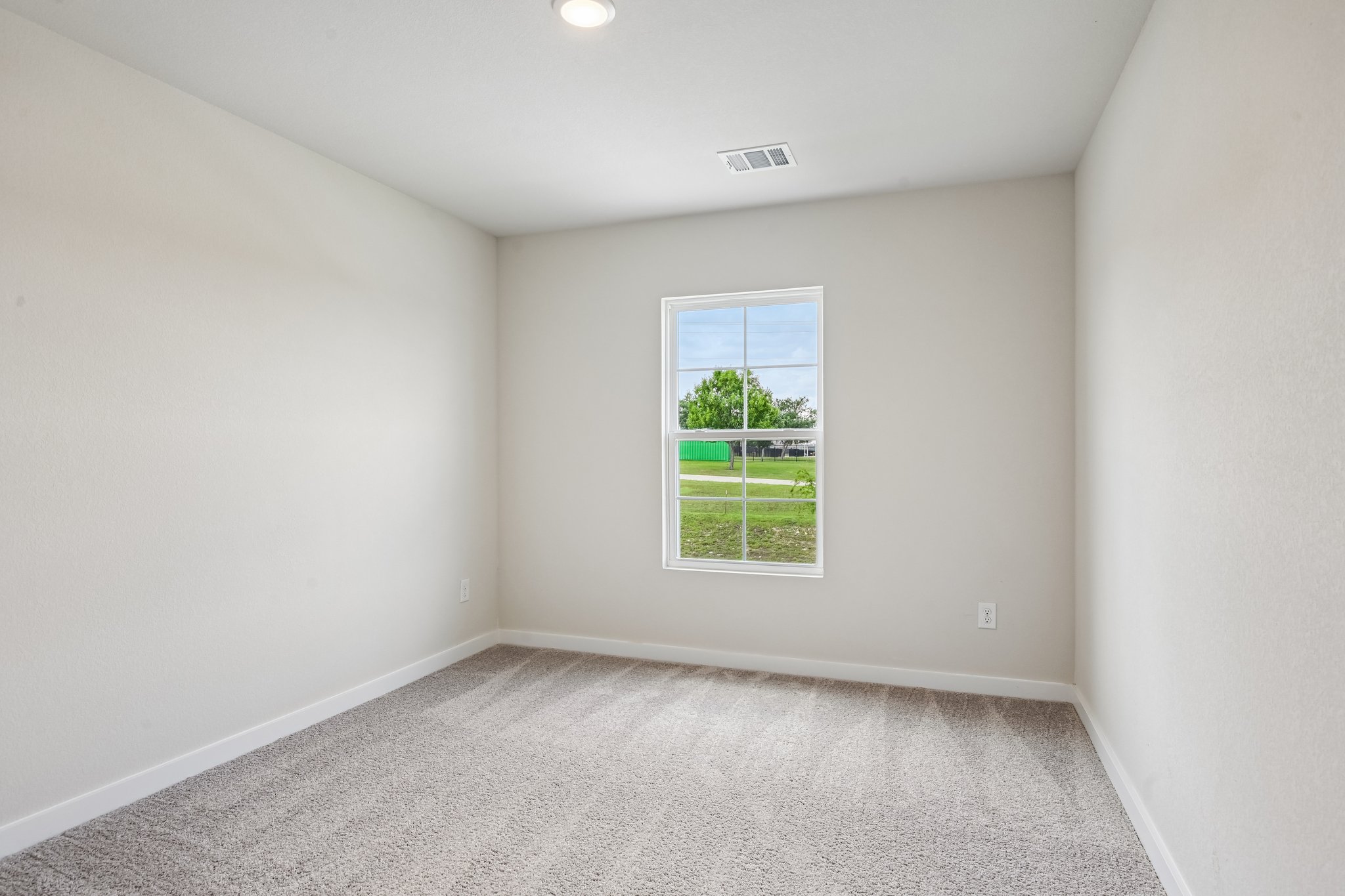A room with a window and a carpet.