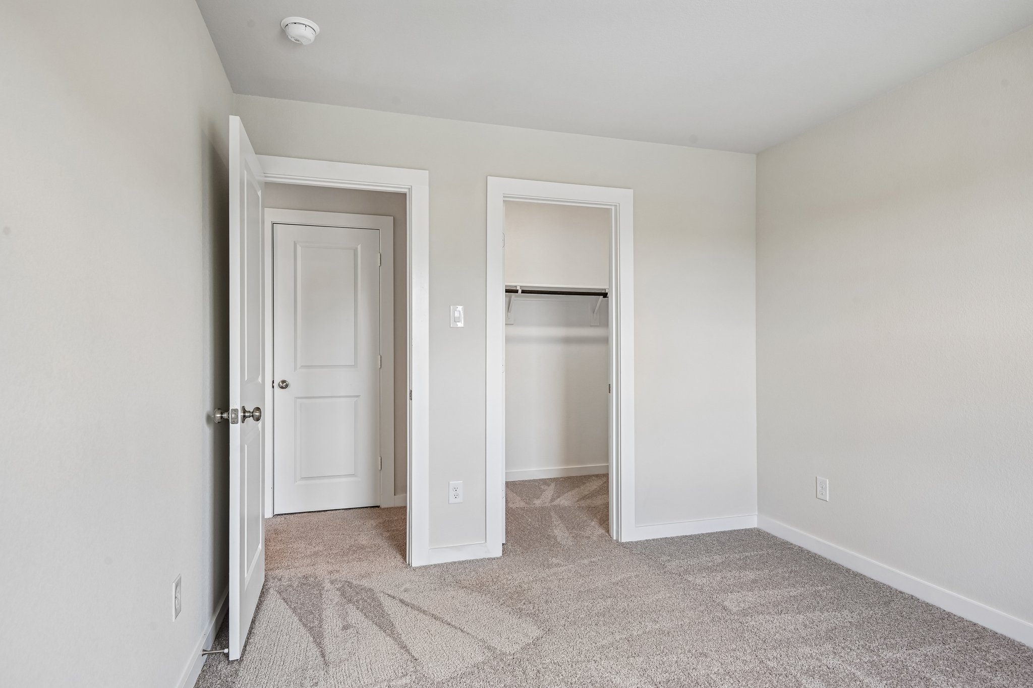 A room with white walls and a couple of doors.