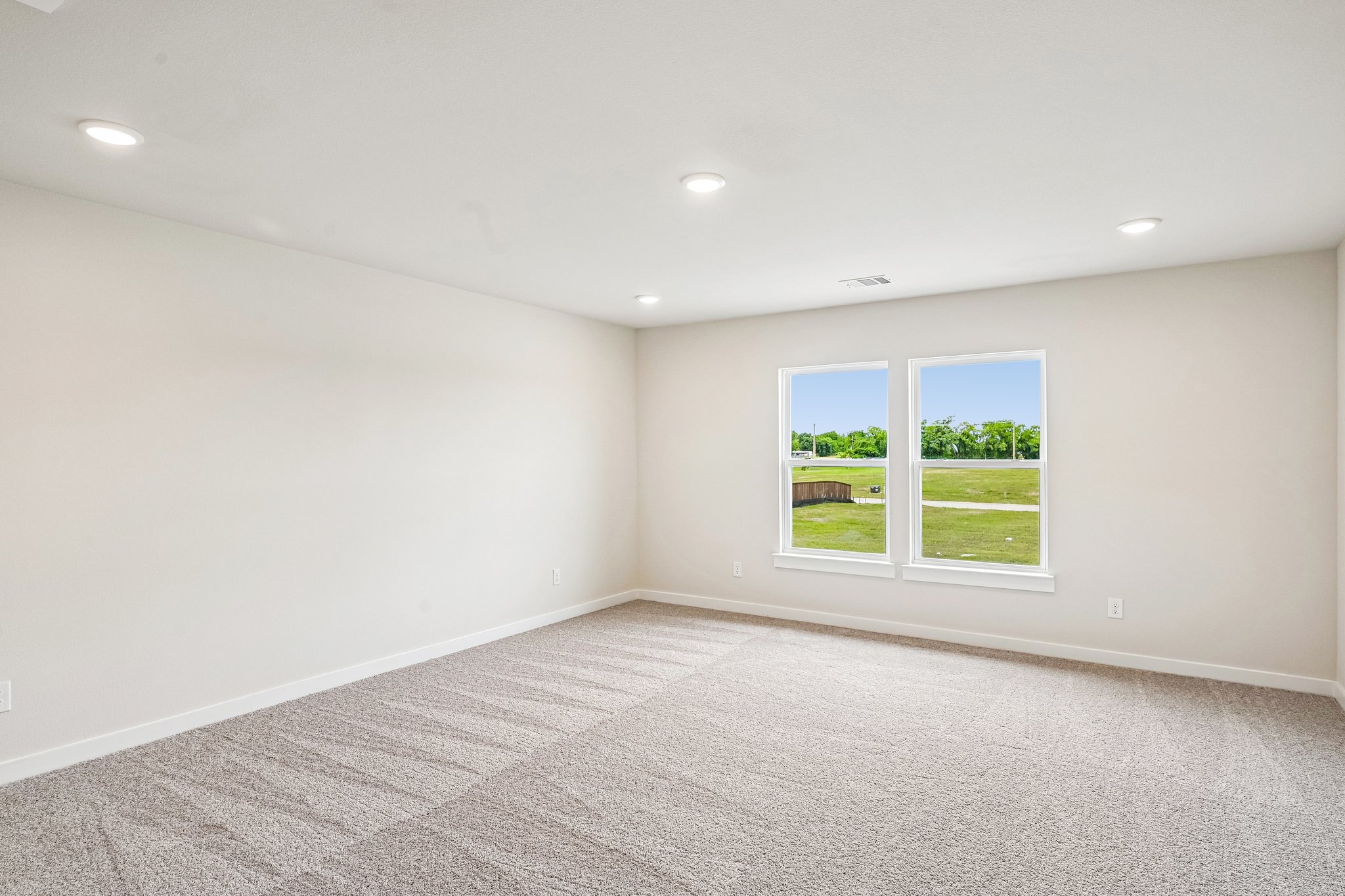 A room with a window and a carpet.