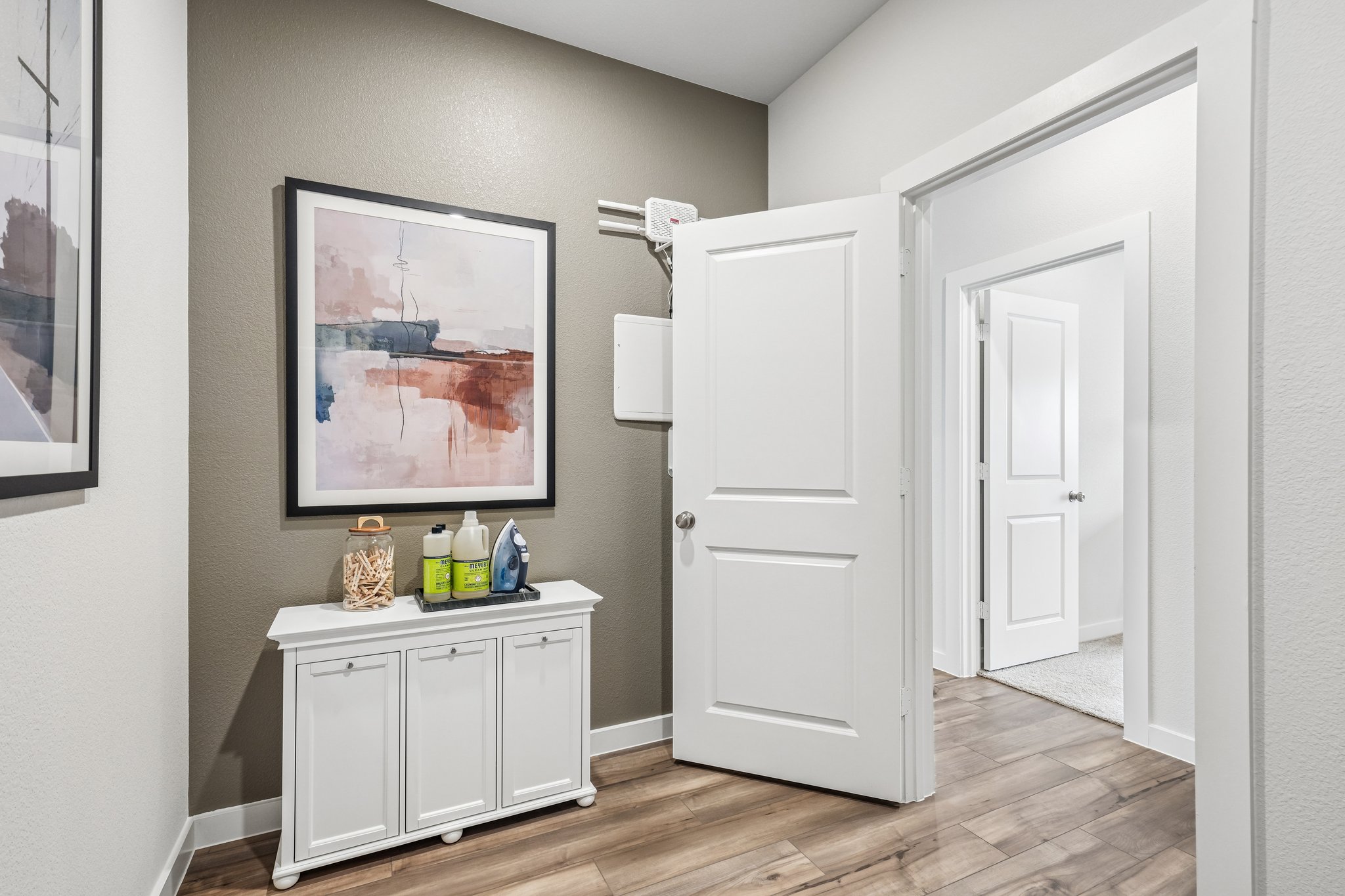 A room with white cabinets and a painting on the wall.
