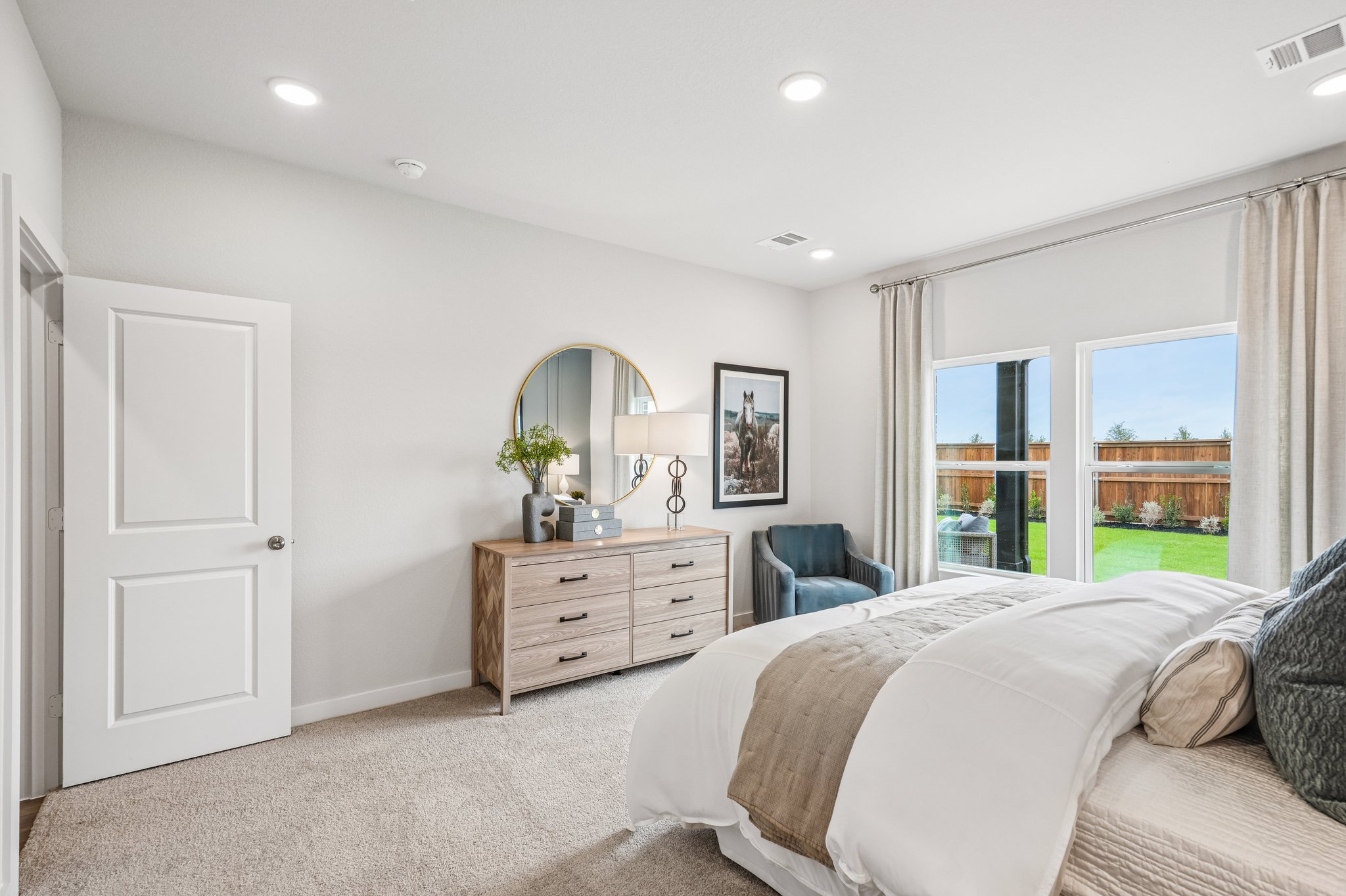 A bedroom with a bed and a mirror.