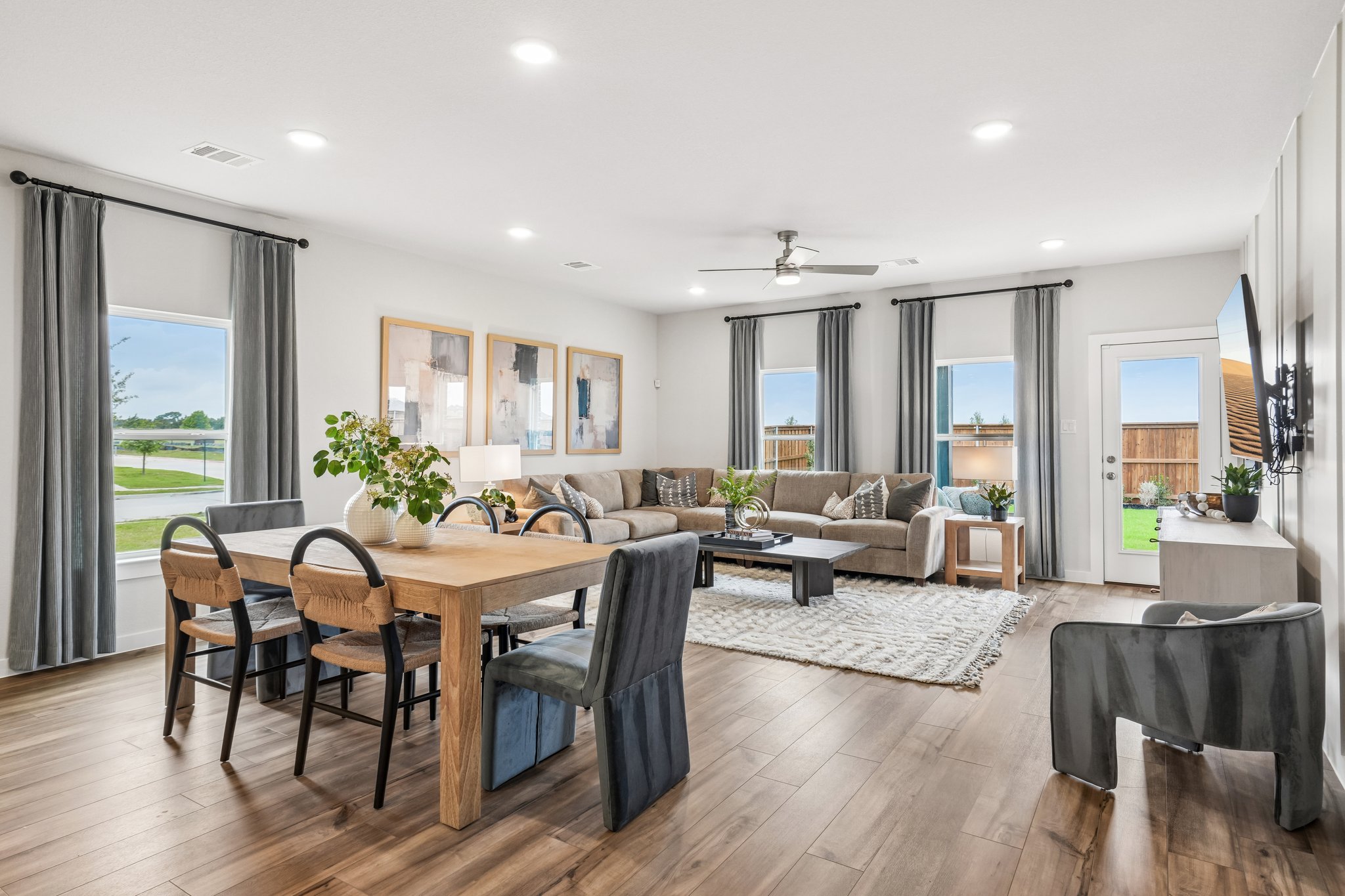 A large living room with a large dining table and a large window.