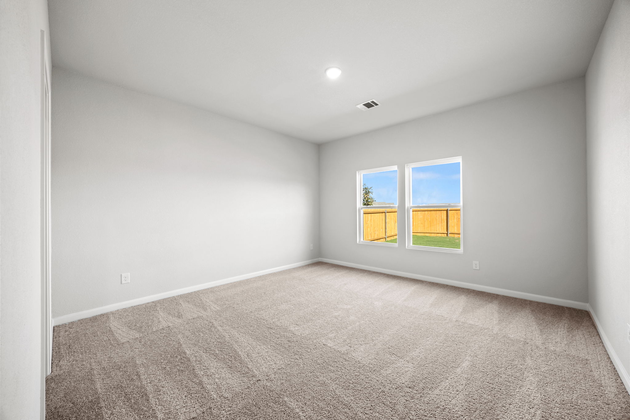 A room with a carpet and windows.