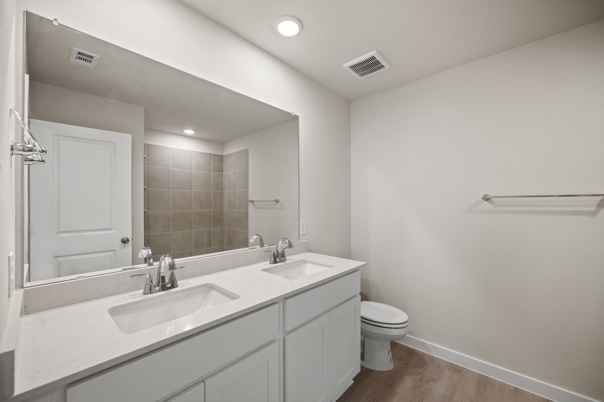 A bathroom with a sink toilet and mirror.