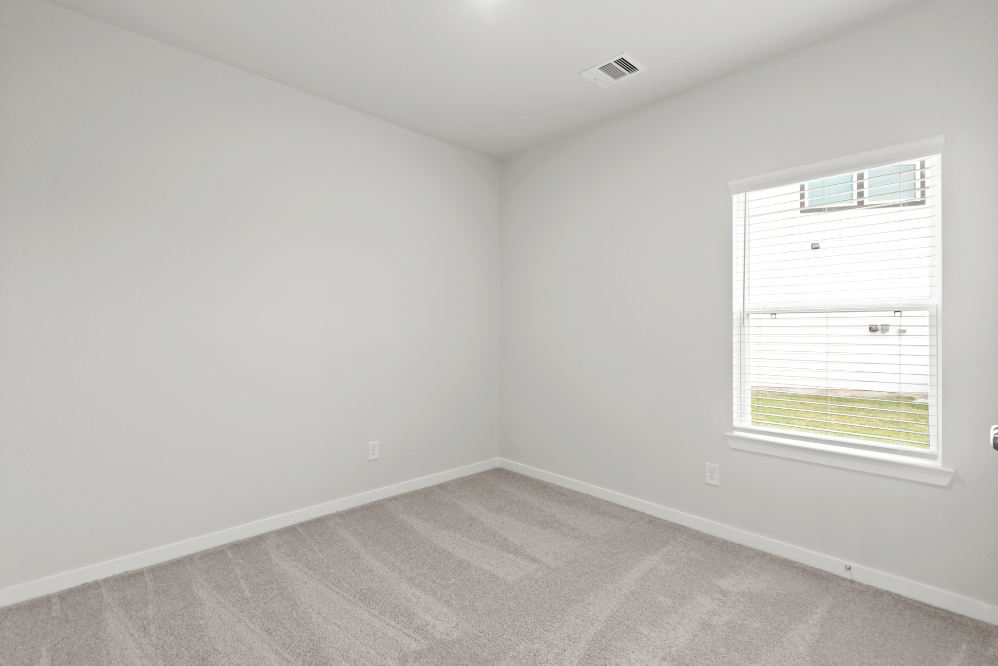 A room with a window and a carpet.