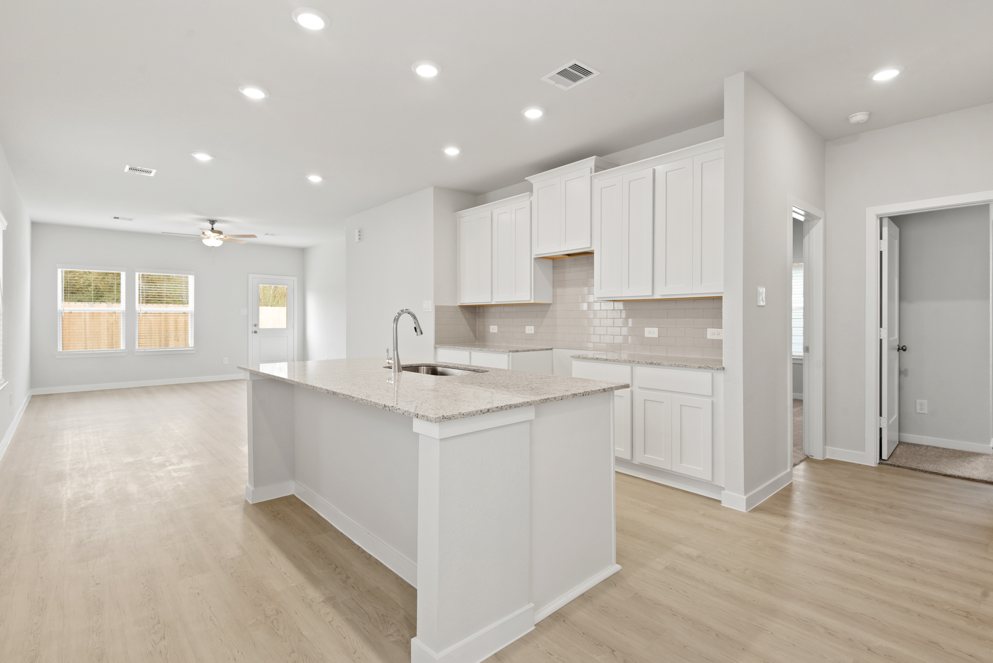 A kitchen with white cabinets.