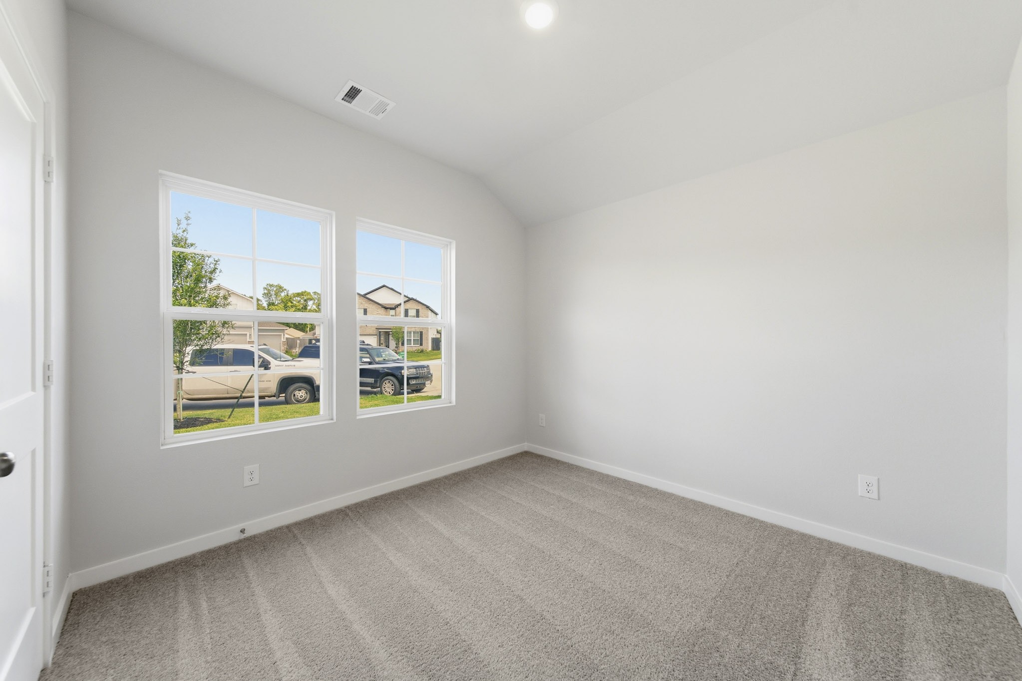 A room with a window and a car outside.