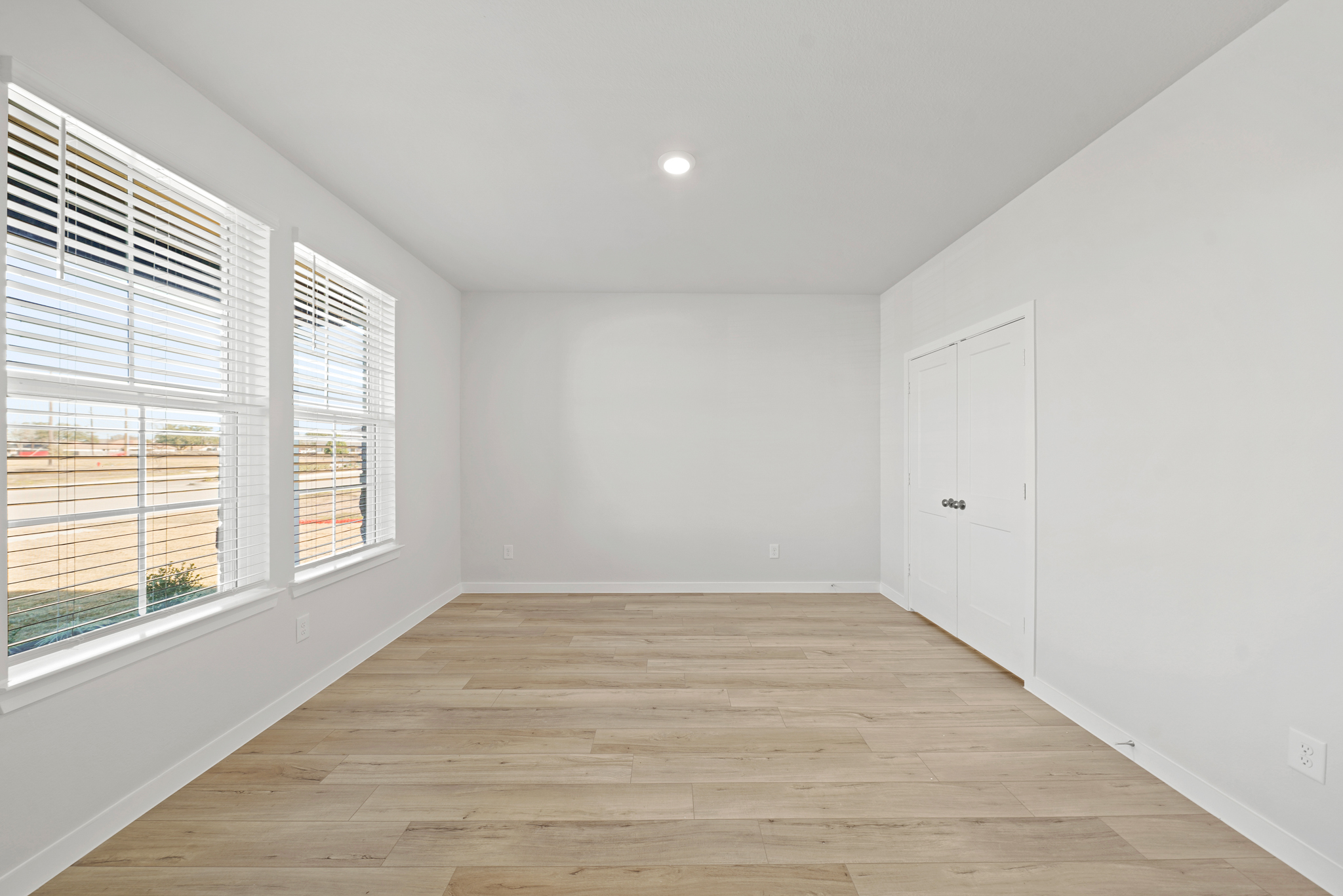 A room with a wood floor and white walls.