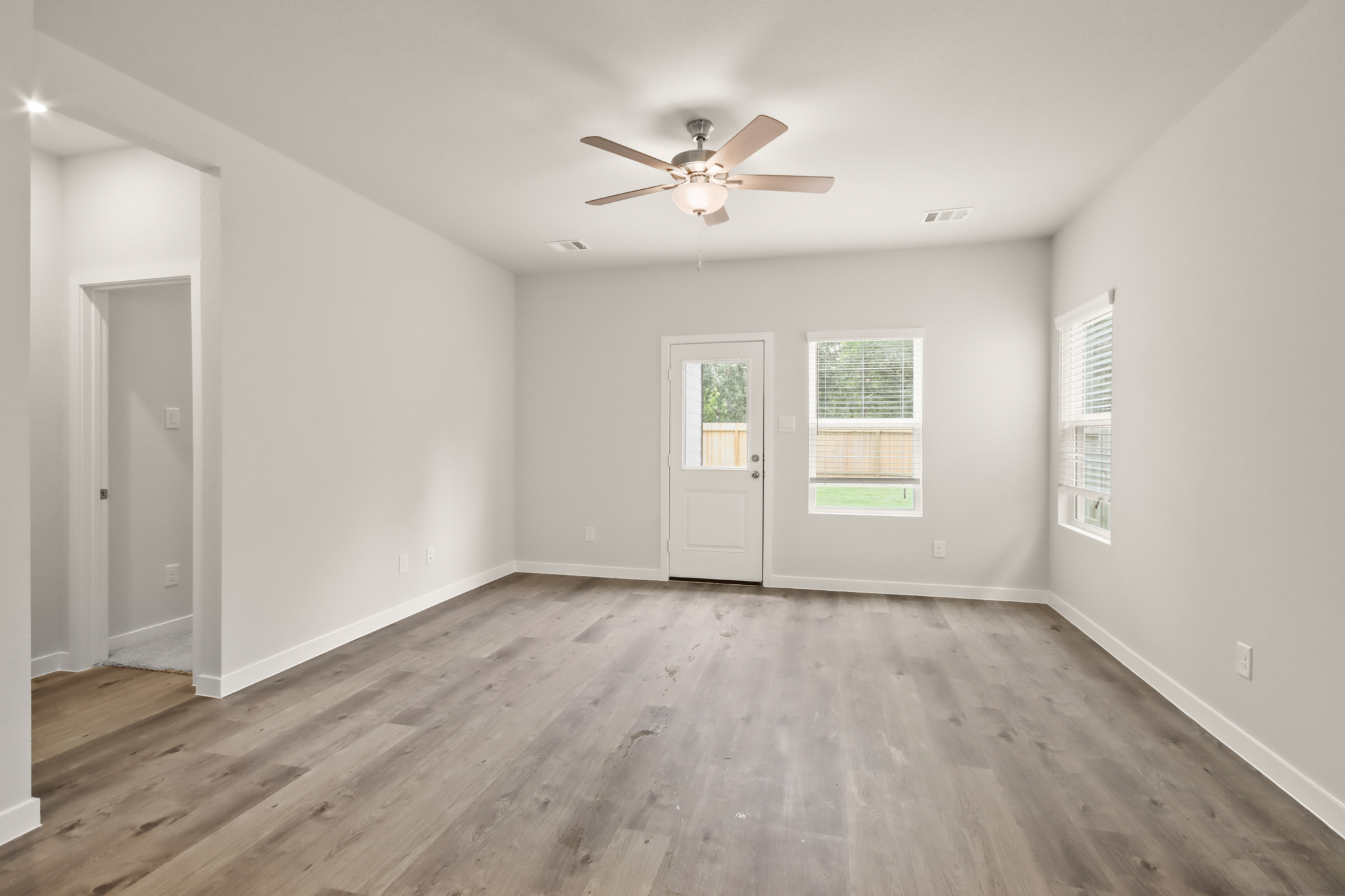 A room with a wood floor and a ceiling fan.