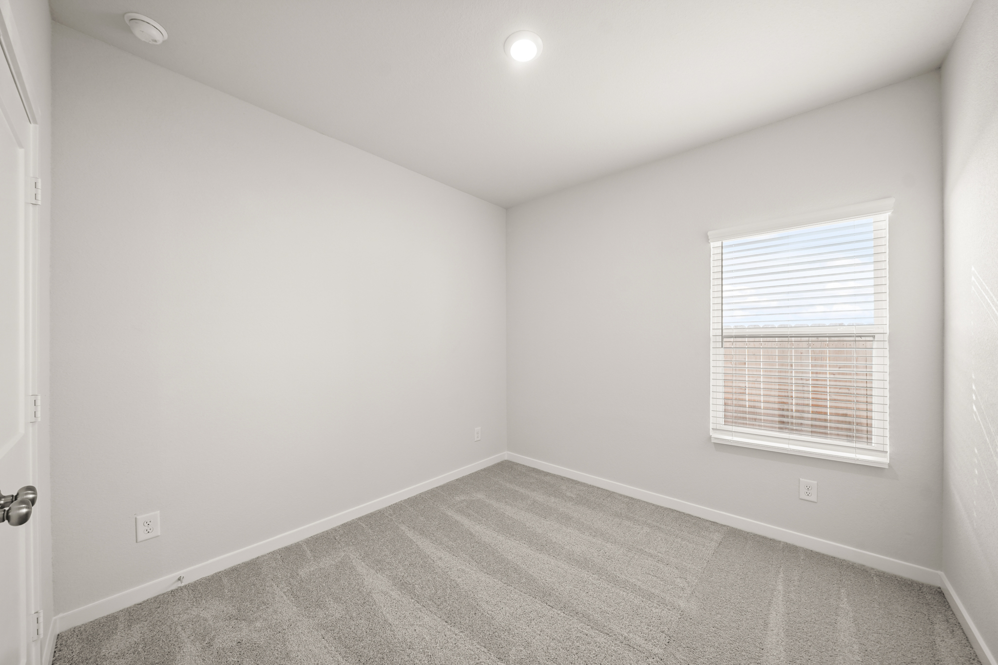 A room with a carpet and a window.