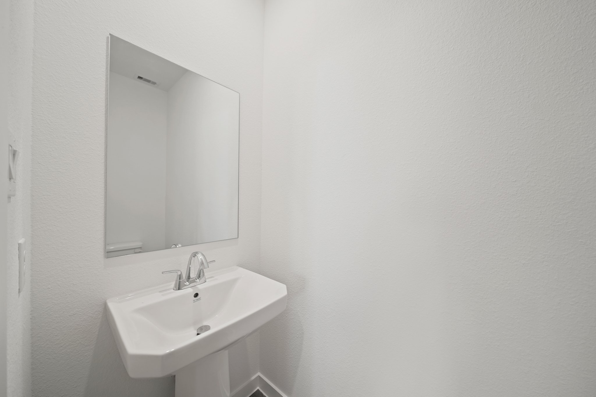 A bathroom with a mirror and sink.