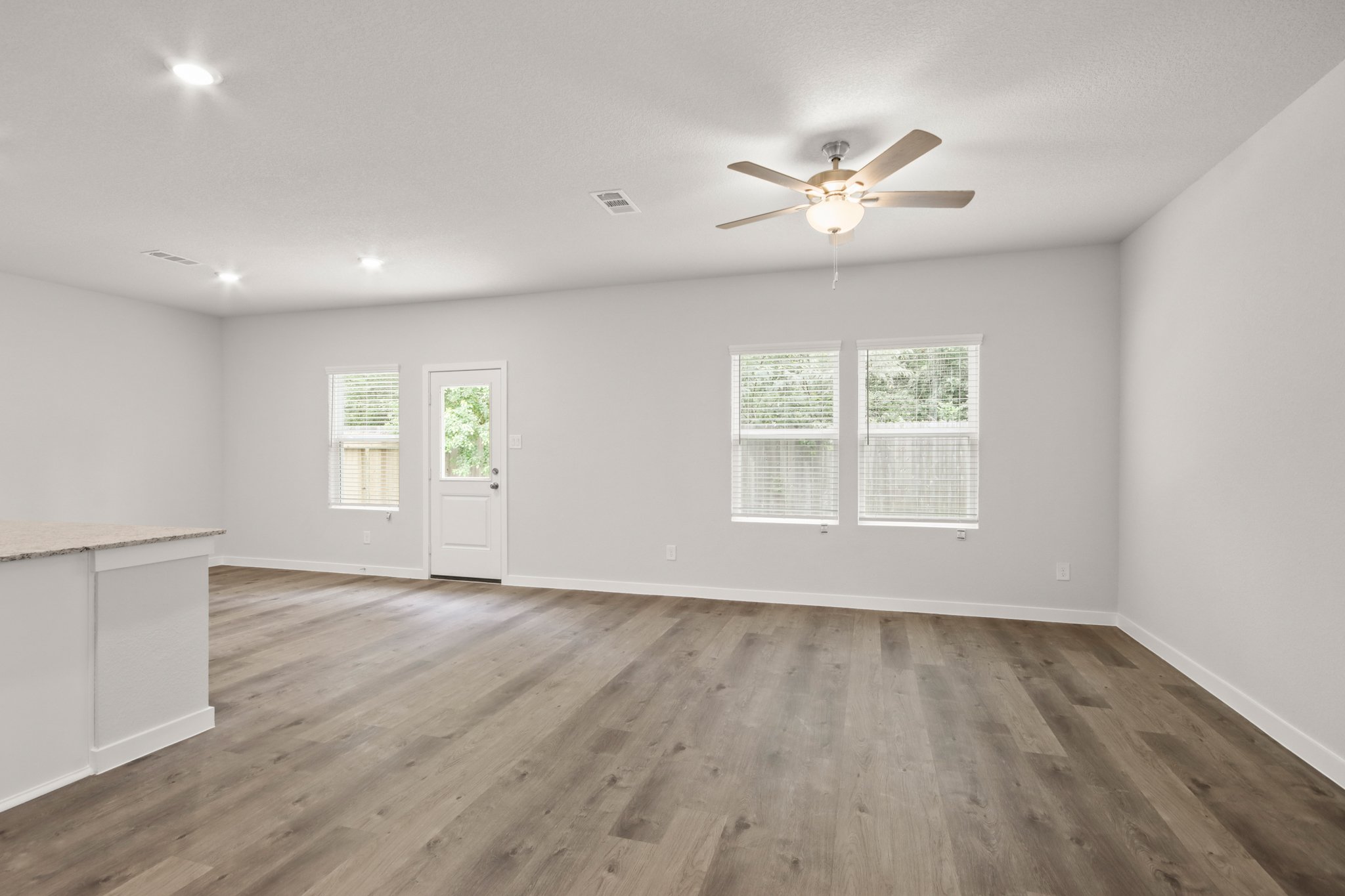 A room with a wood floor and a ceiling fan.
