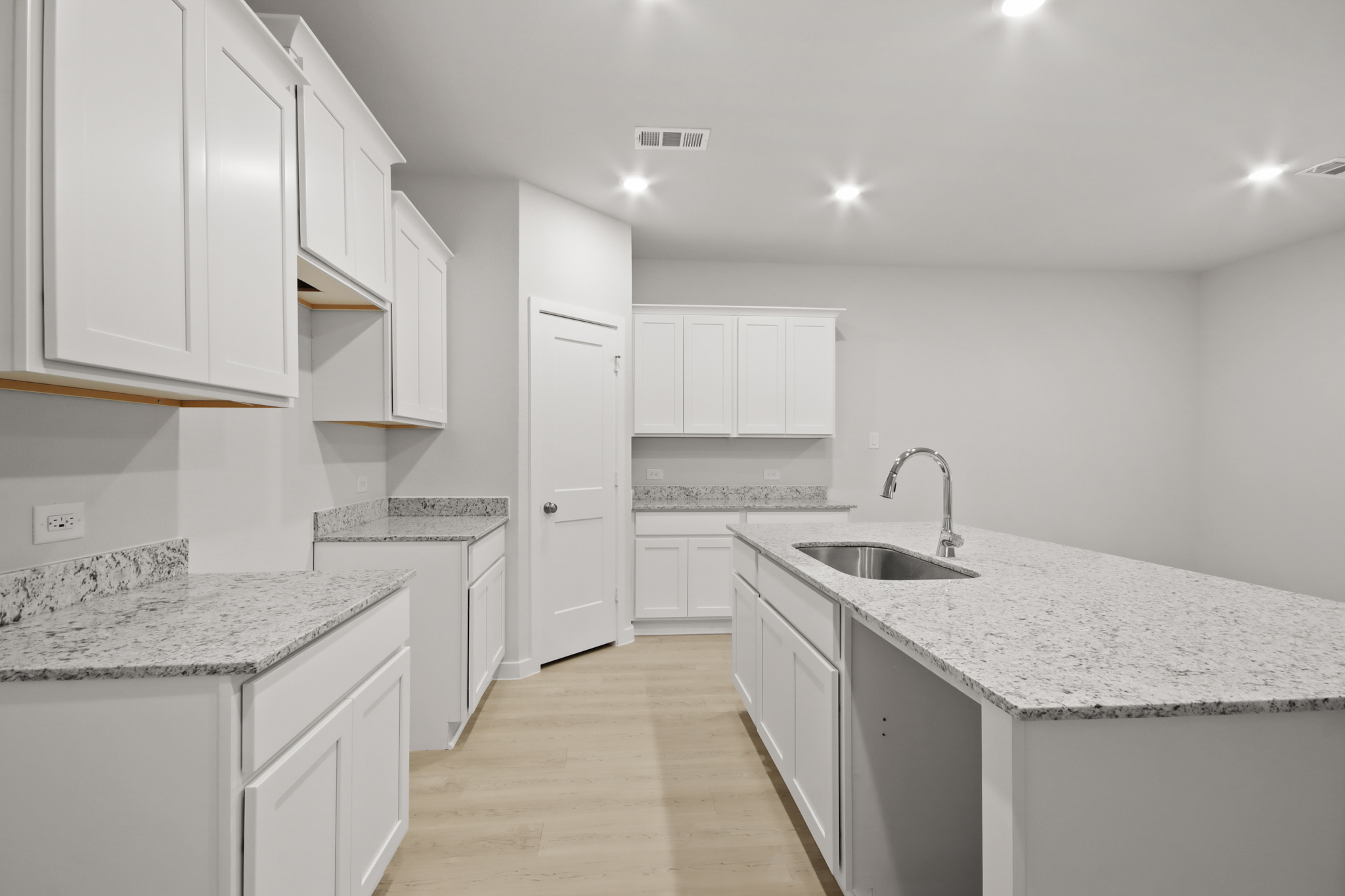 A kitchen with white cabinets.