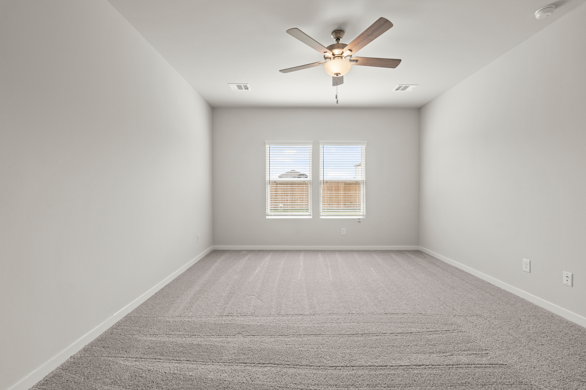 A room with a ceiling fan and a window.