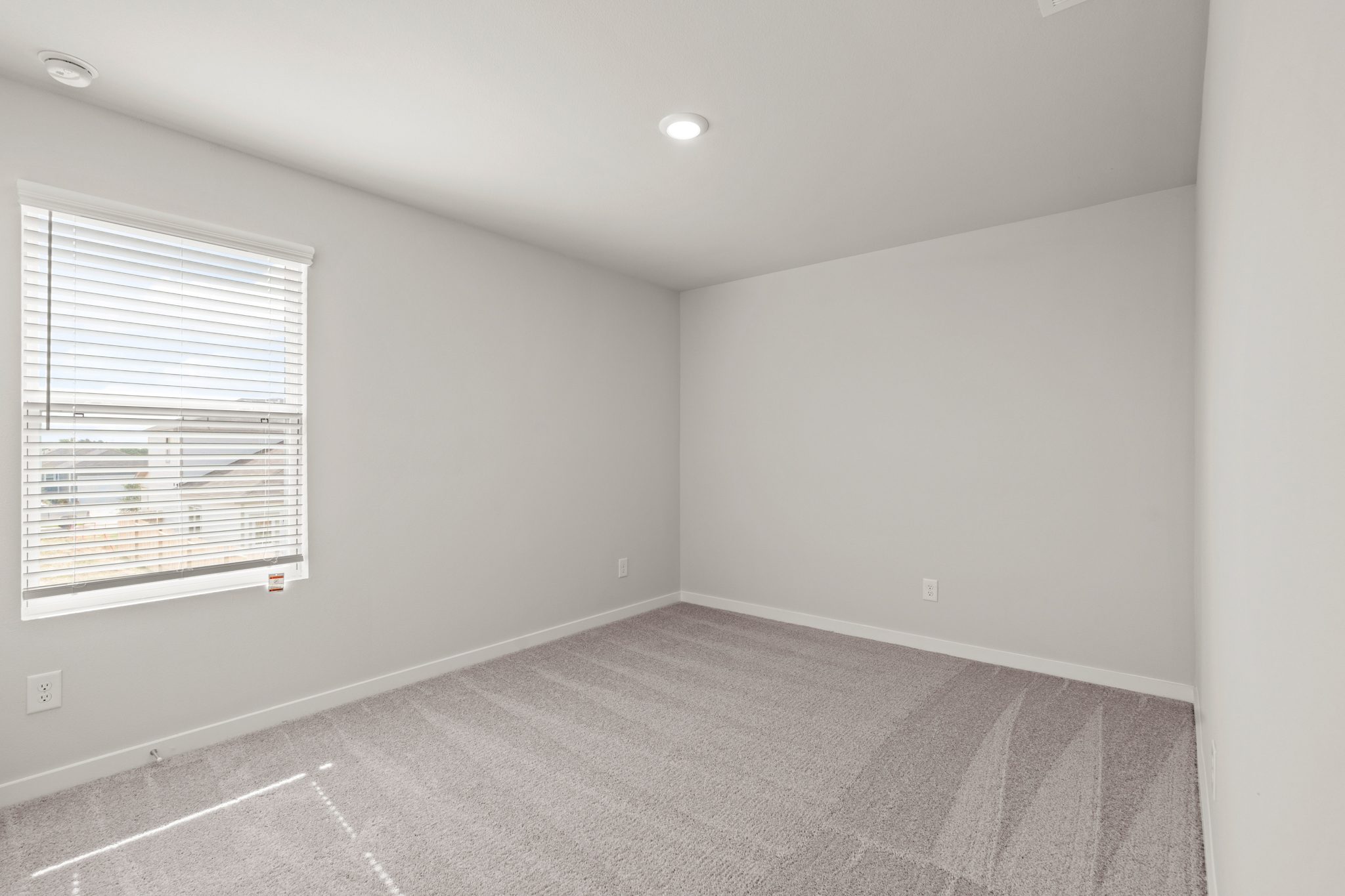 A room with a carpet and a window.