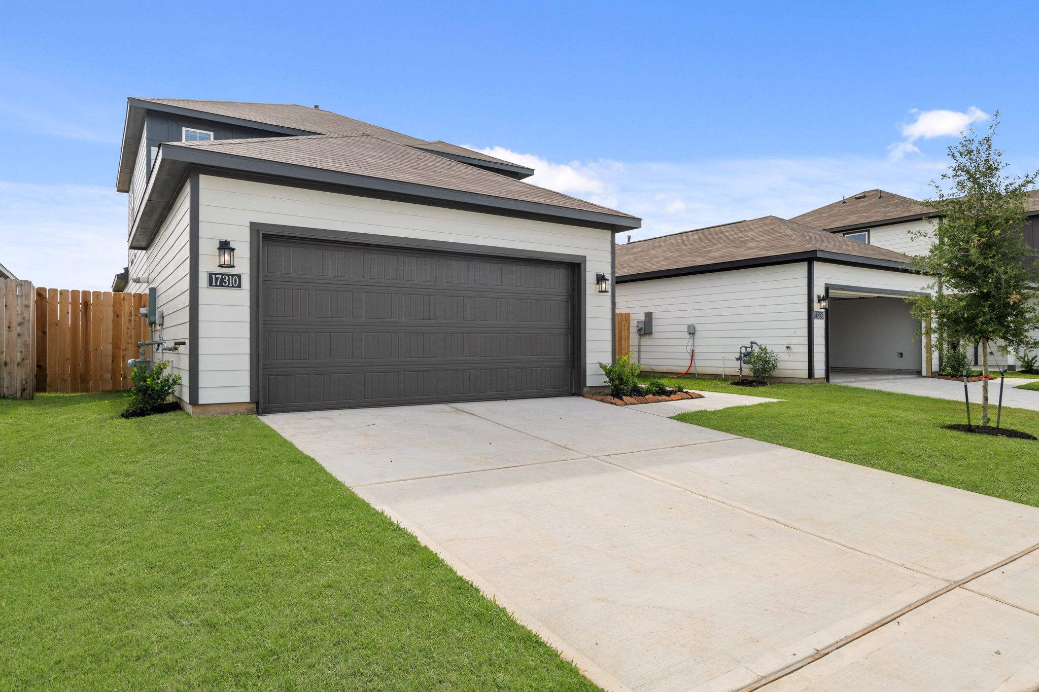 A house with garages and a sidewalk.