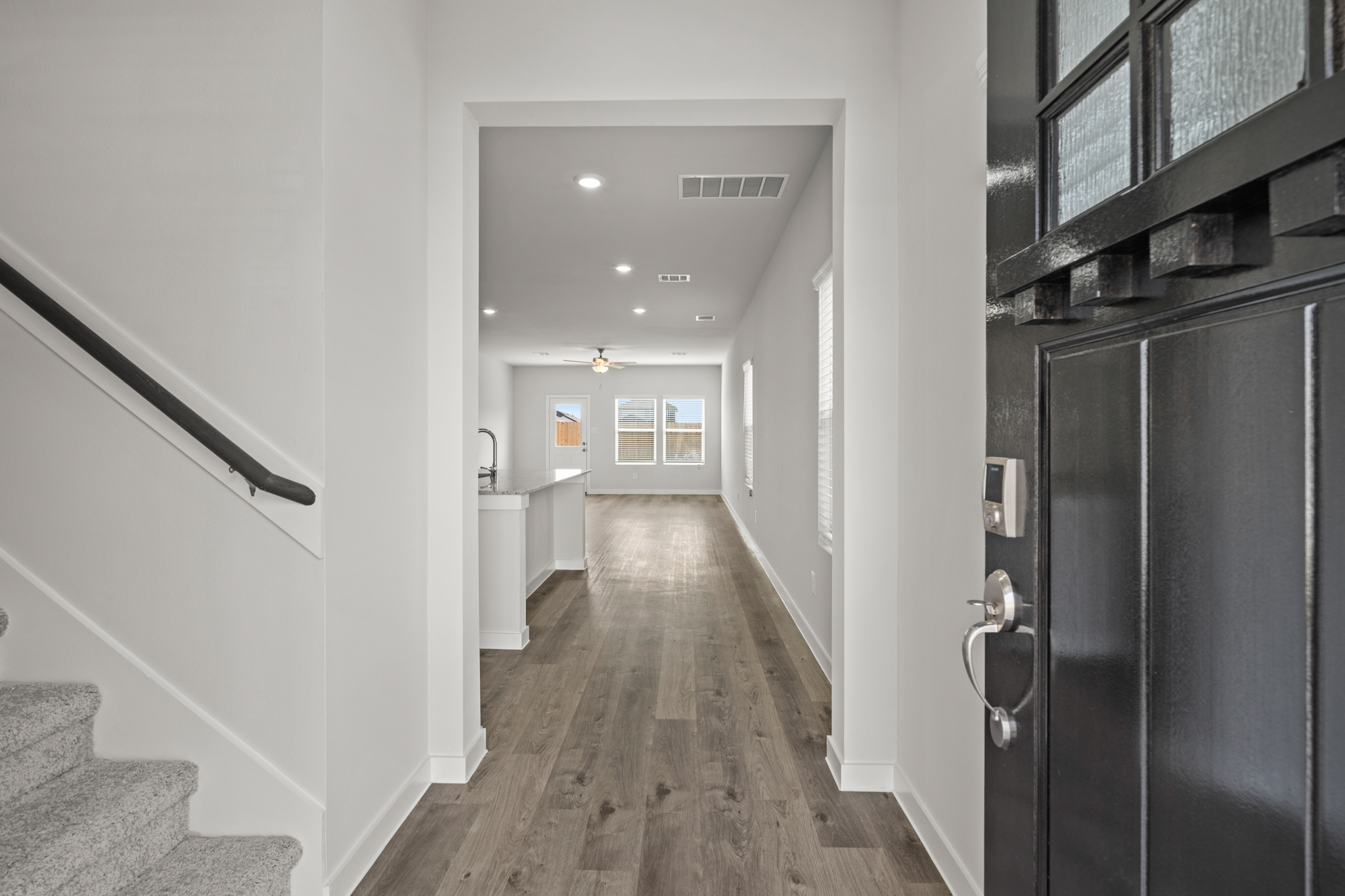 A hallway with a refrigerator.