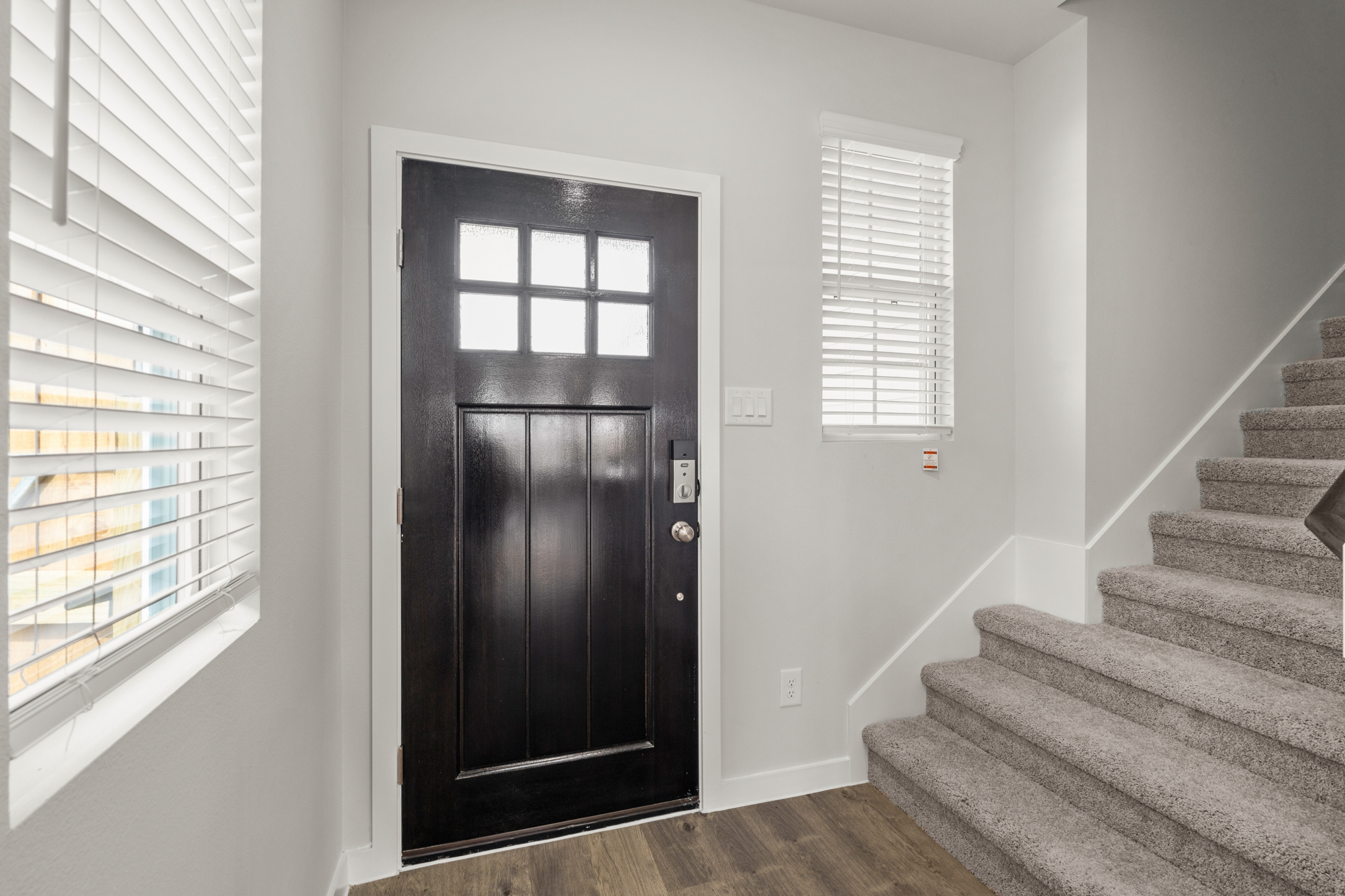 A black door on a white wall.