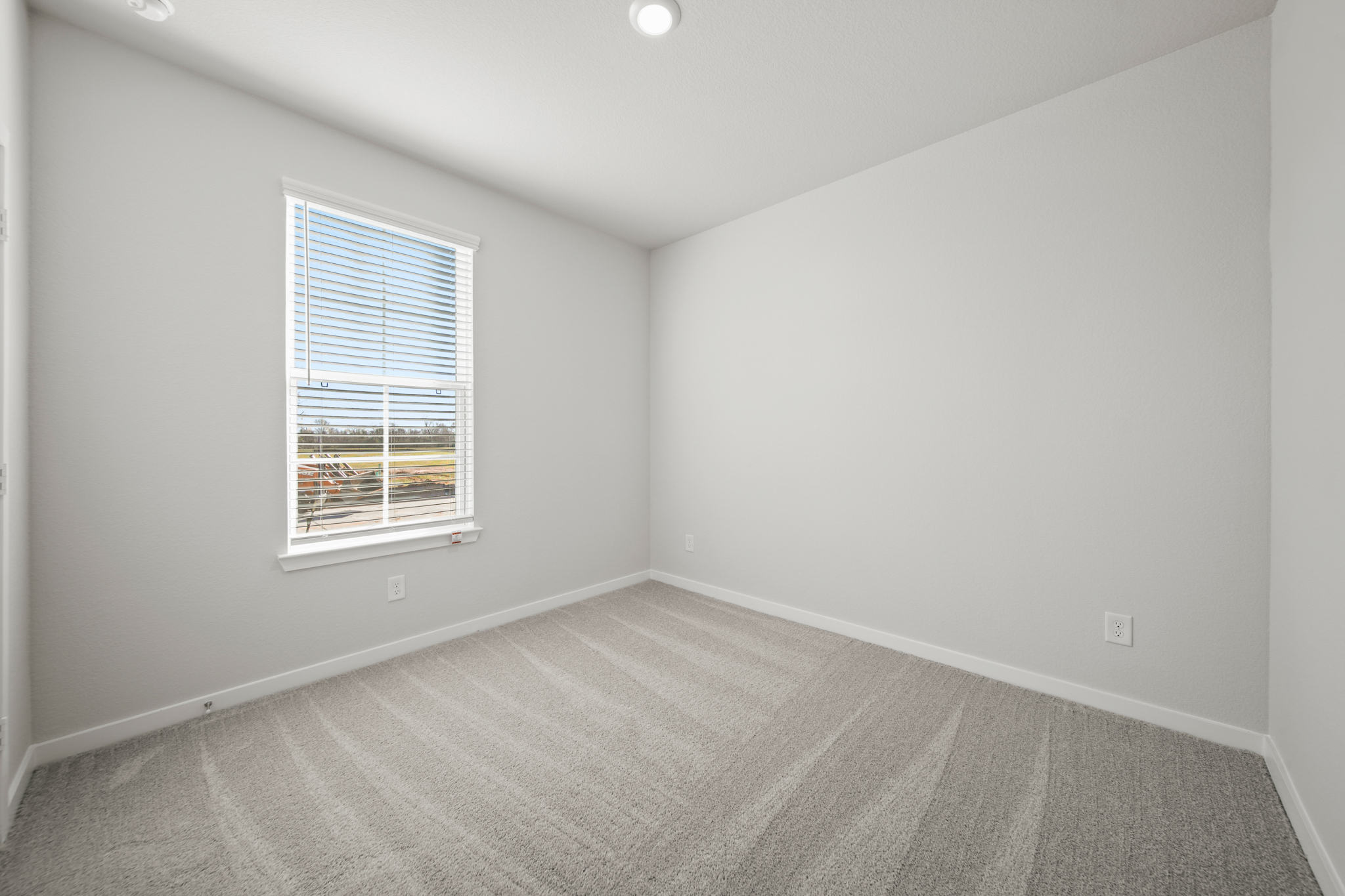 A room with a window and a carpet.