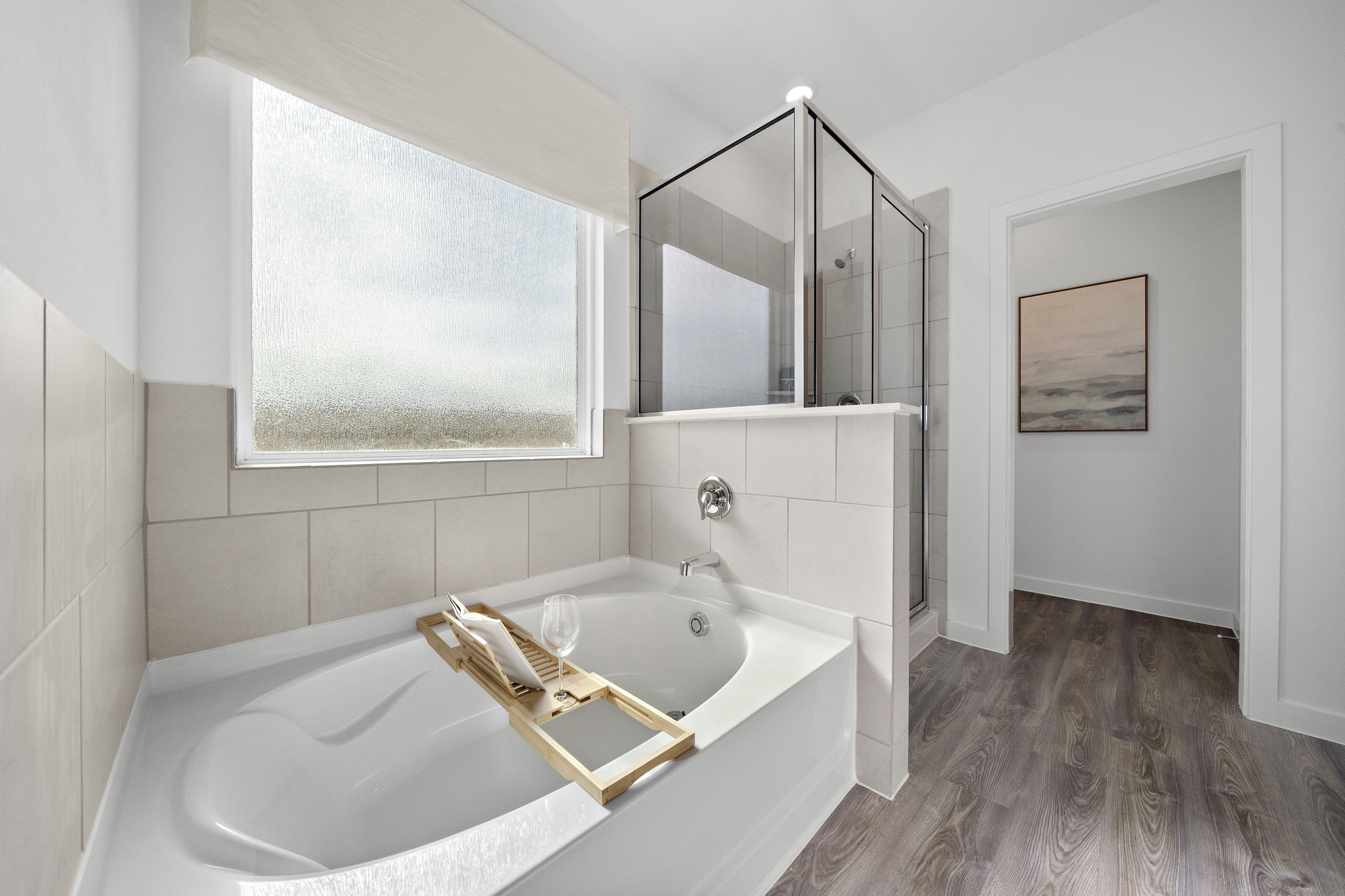 A bathroom with a tub sink and a mirror.