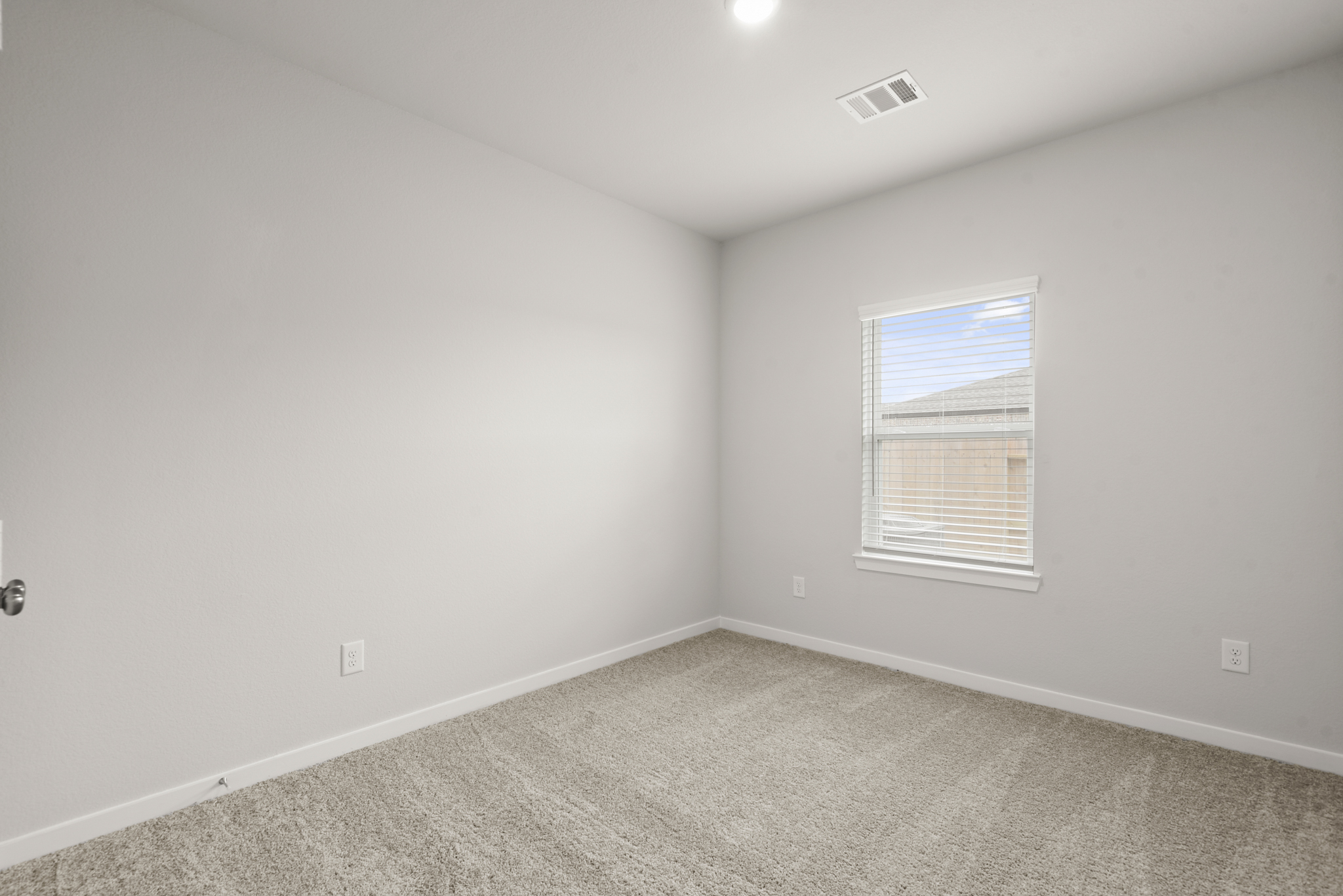 A room with a window and a carpet.