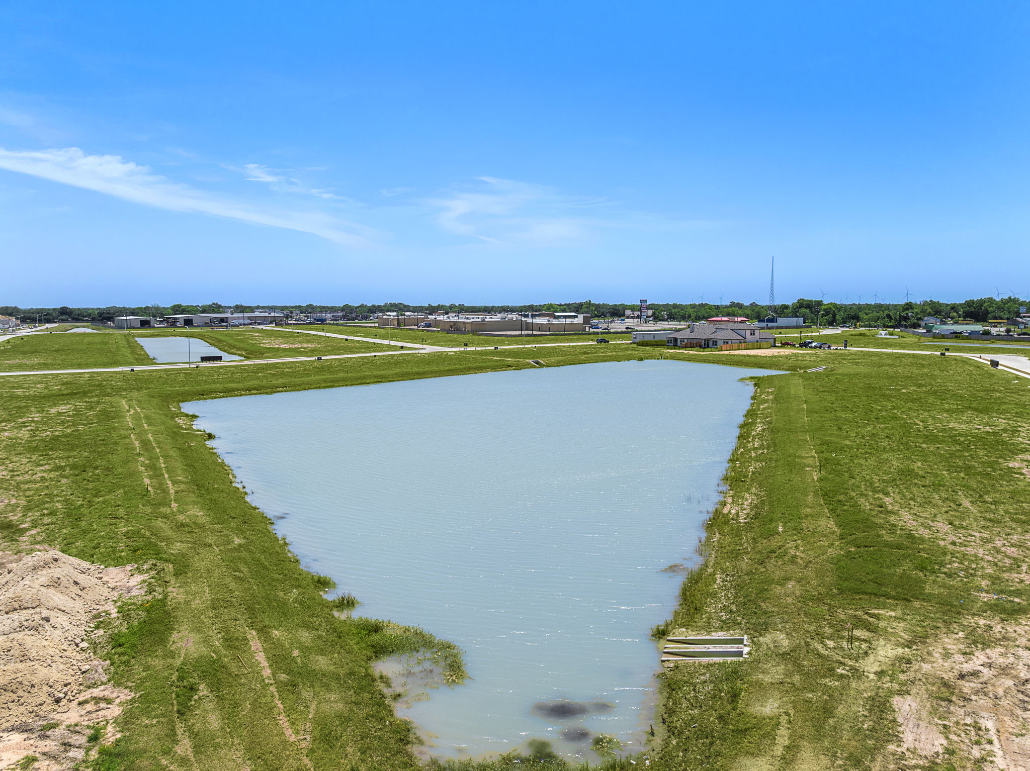 A body of water with grass and buildings around it.