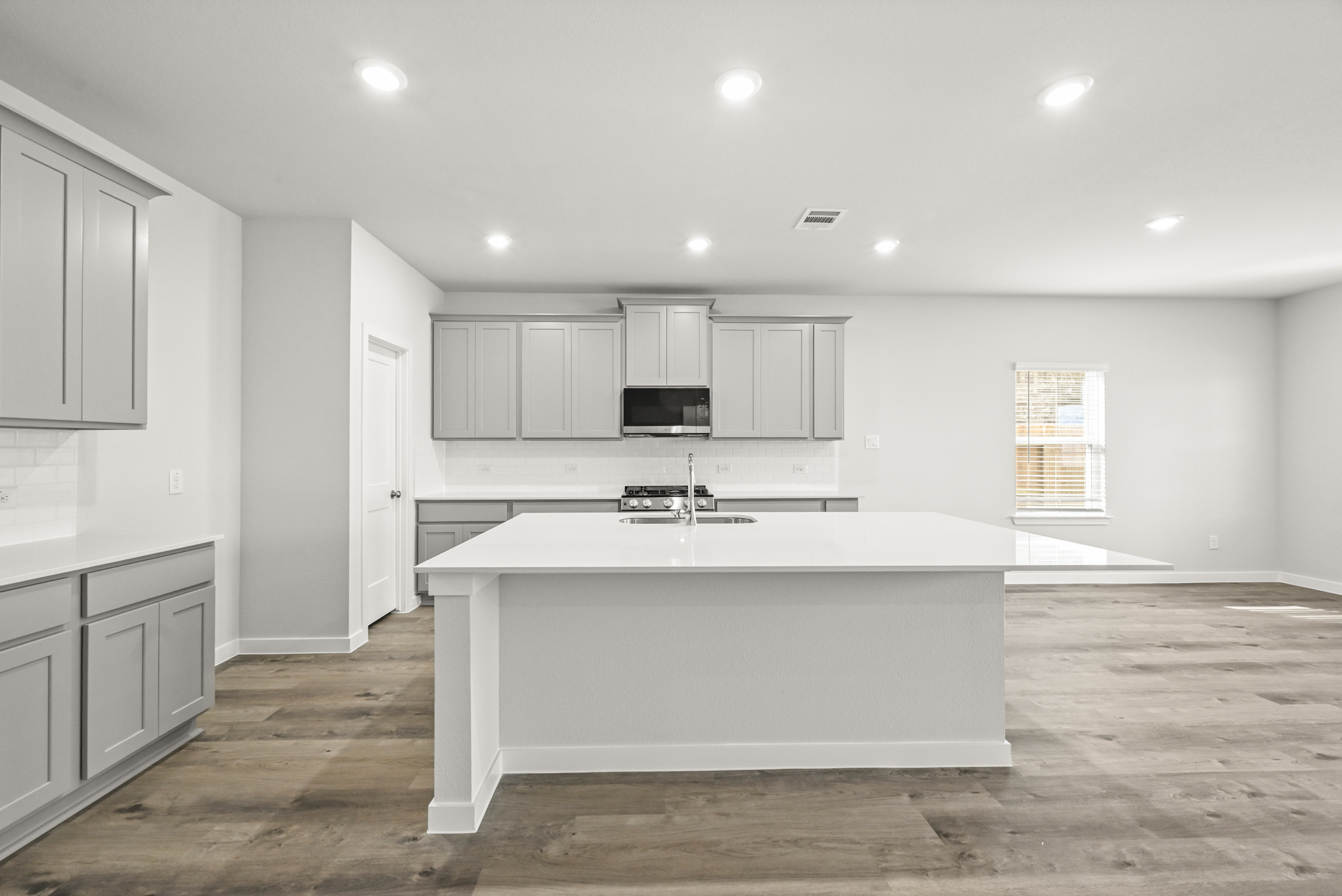 A kitchen with white cabinets.