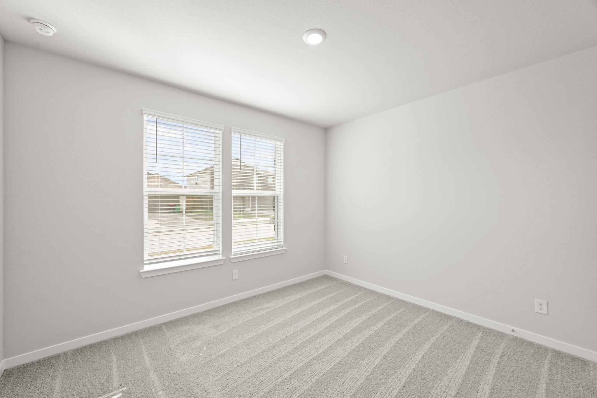 A room with a window and a rug.