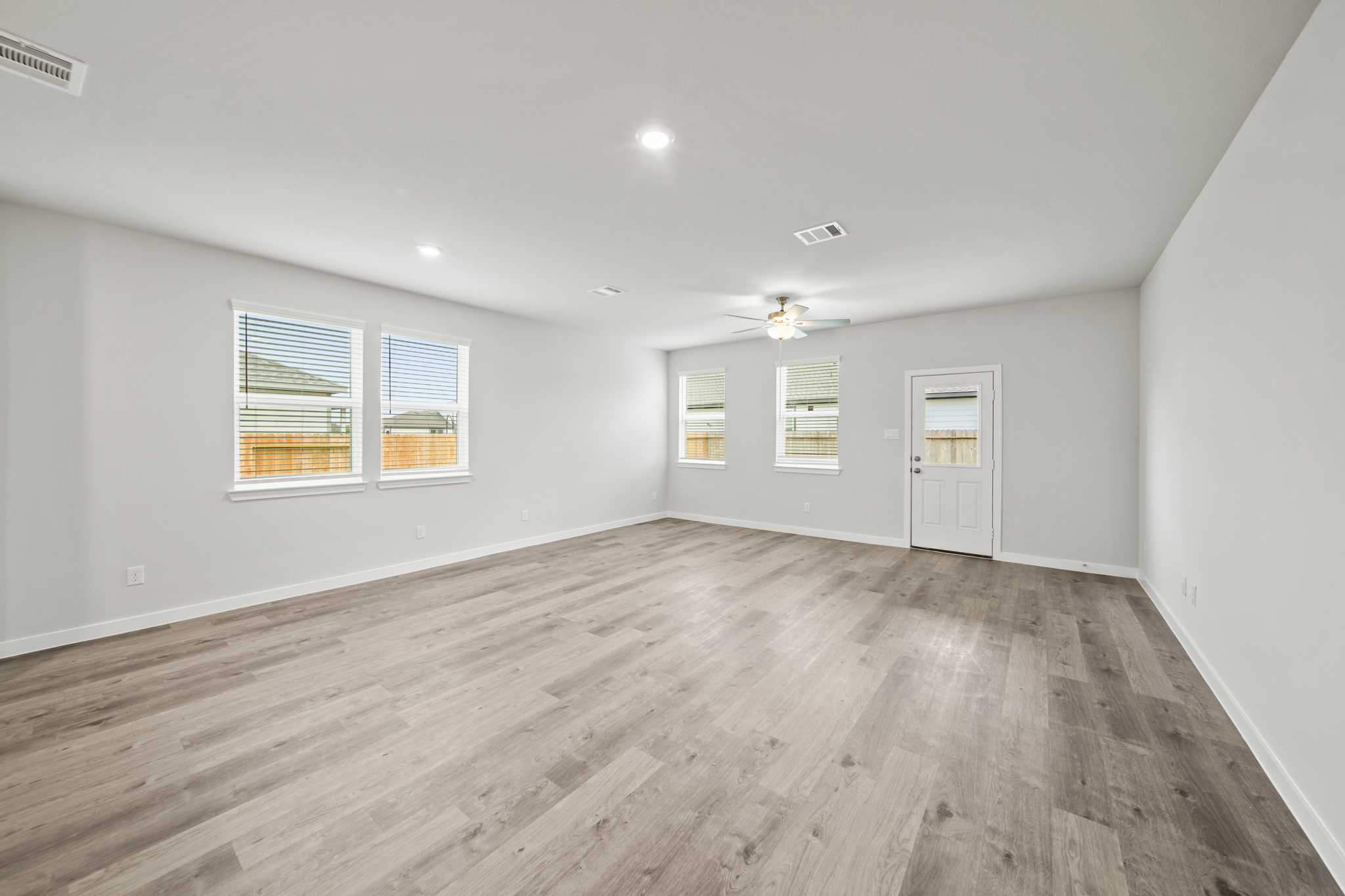 A room with a wood floor and windows.