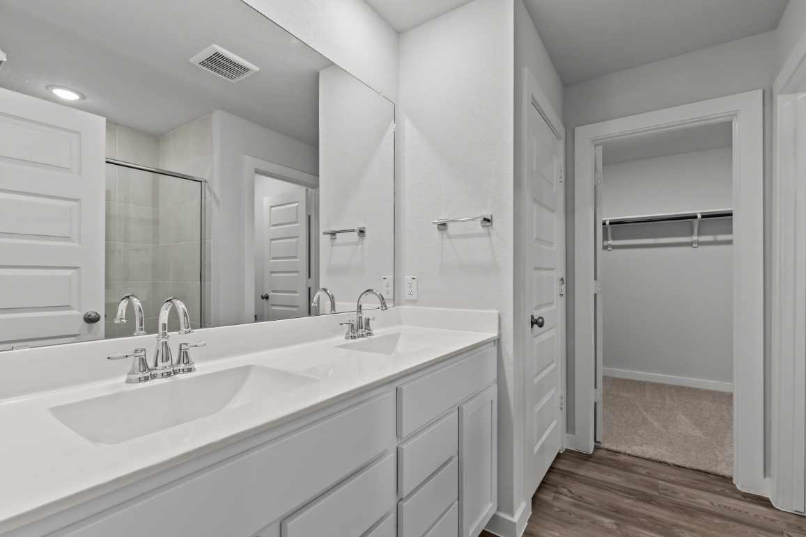 A bathroom with white cabinets.