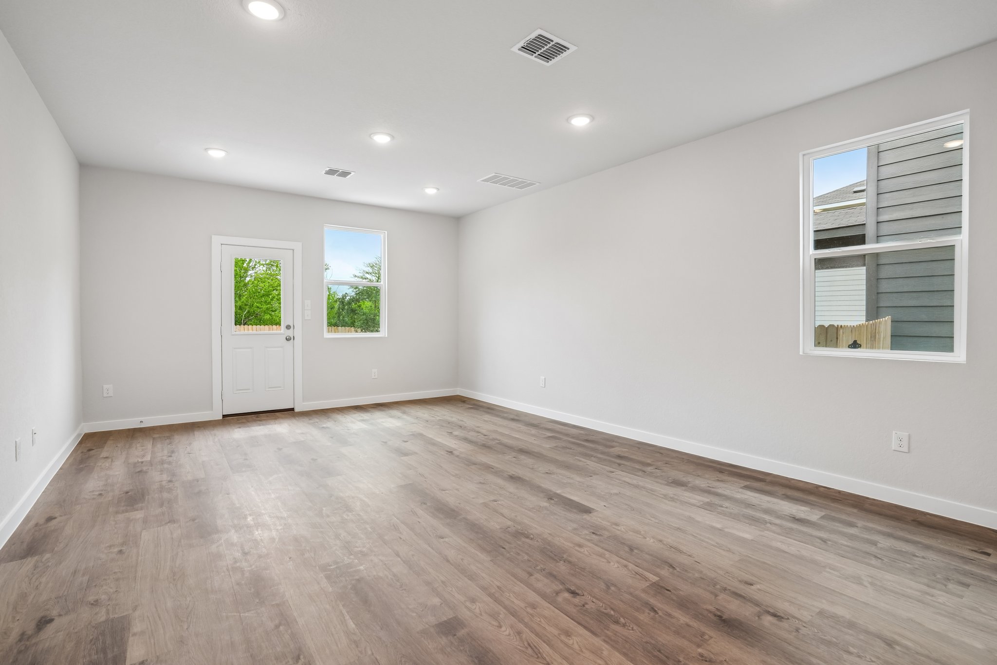 A room with a wood floor and windows.
