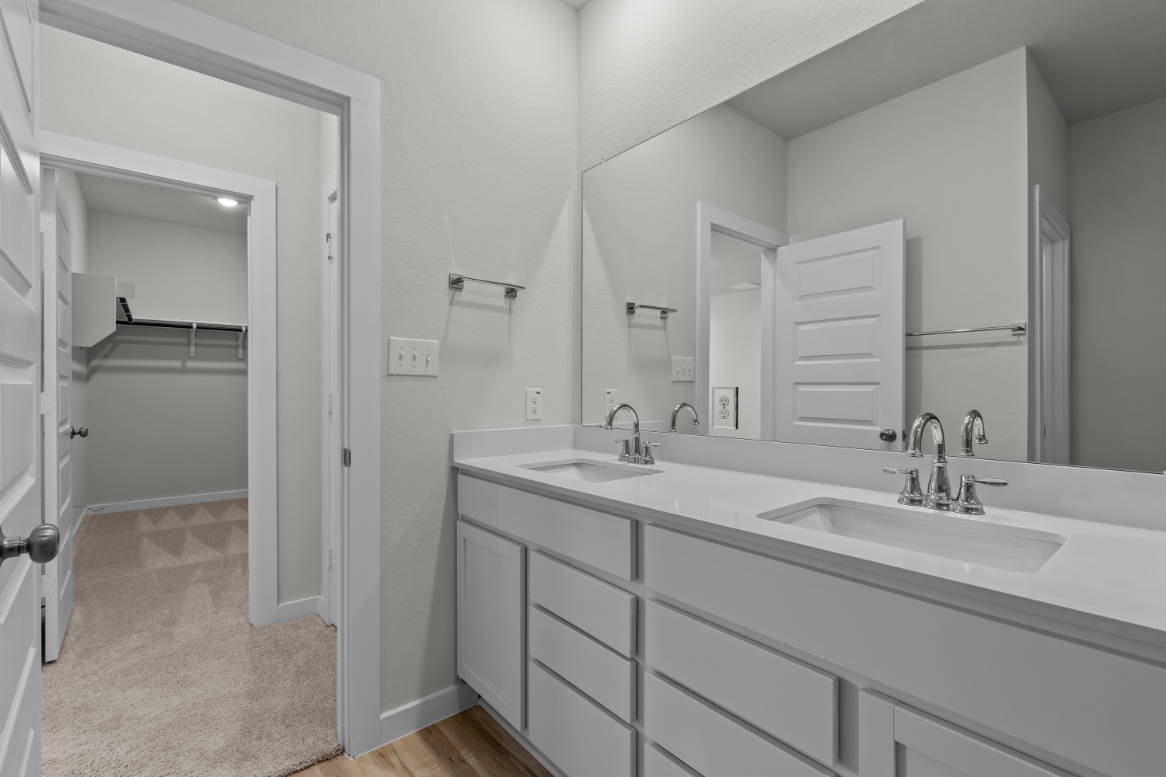 A bathroom with white cabinets.