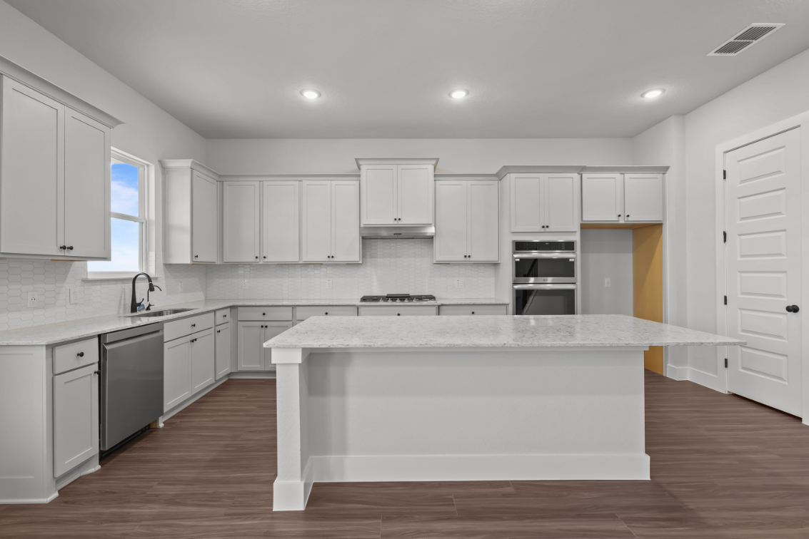 A kitchen with white cabinets.