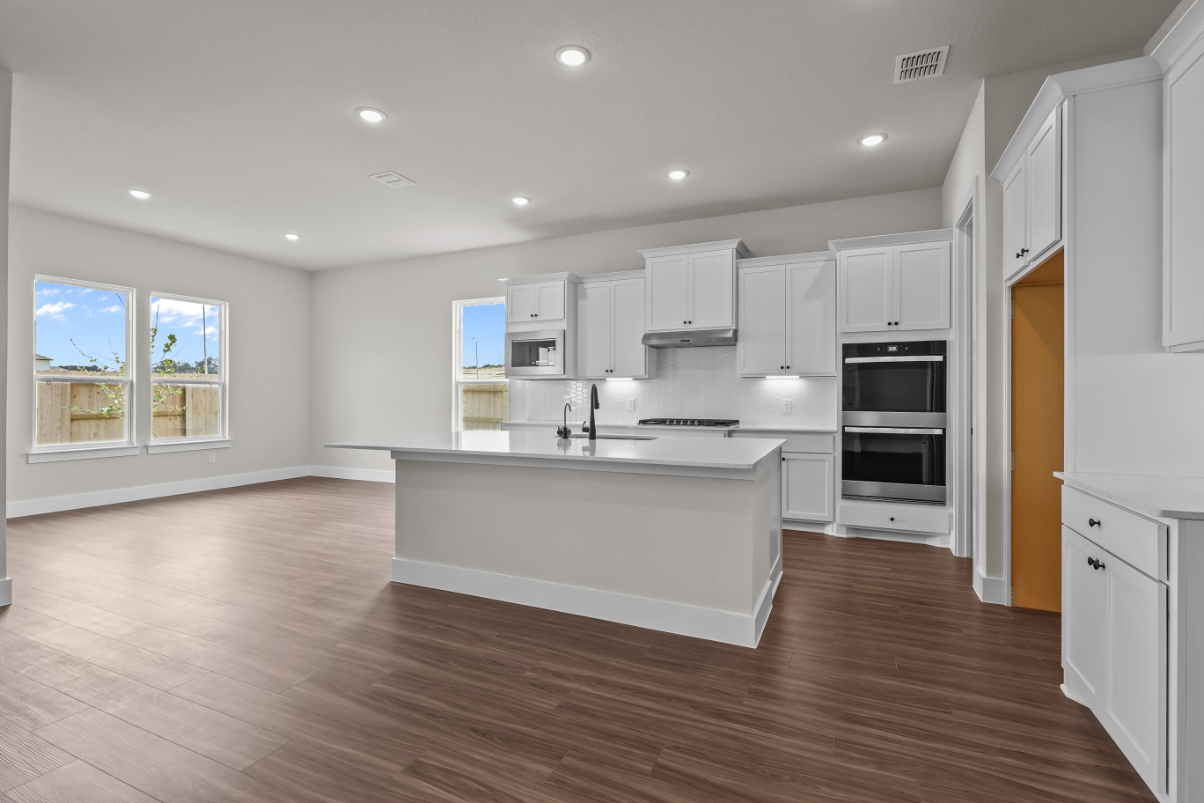 A kitchen with white cabinets.