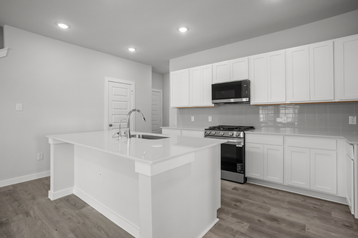 A kitchen with white cabinets.