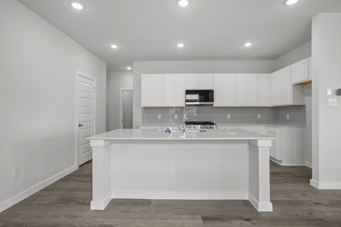 A kitchen with white cabinets.