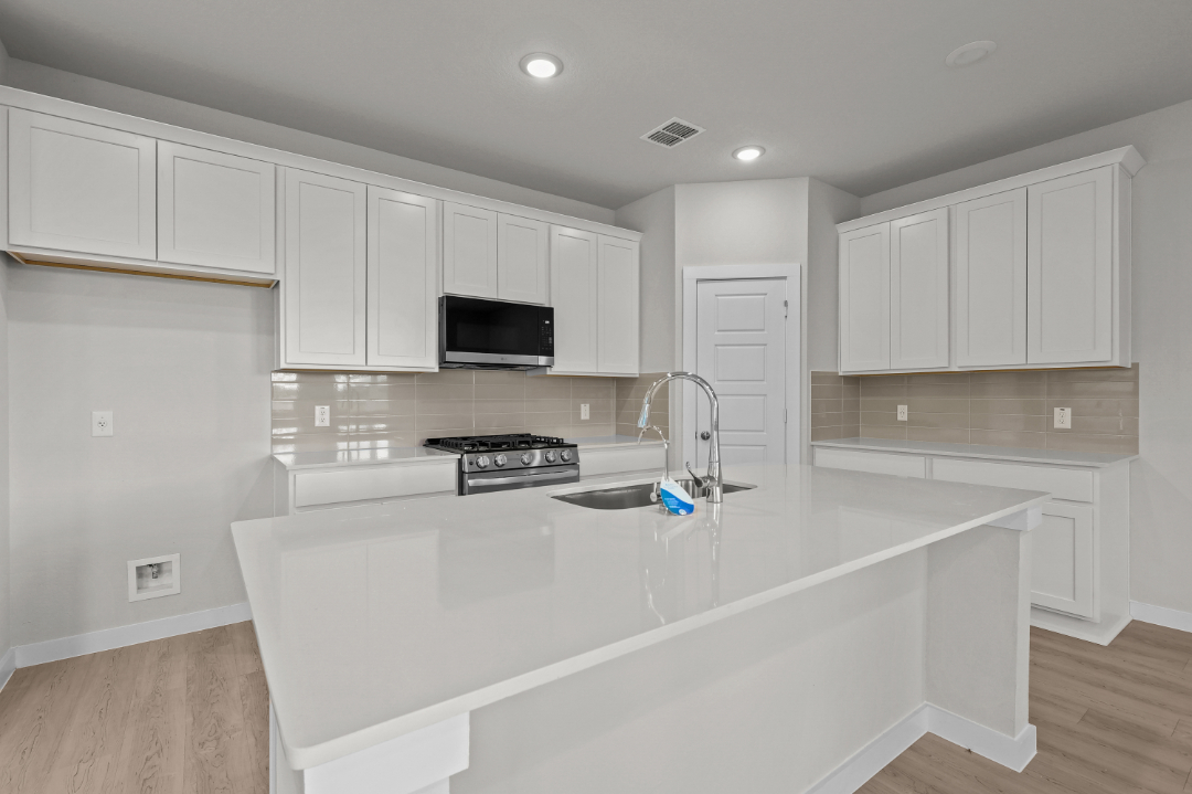 A kitchen with white cabinets.