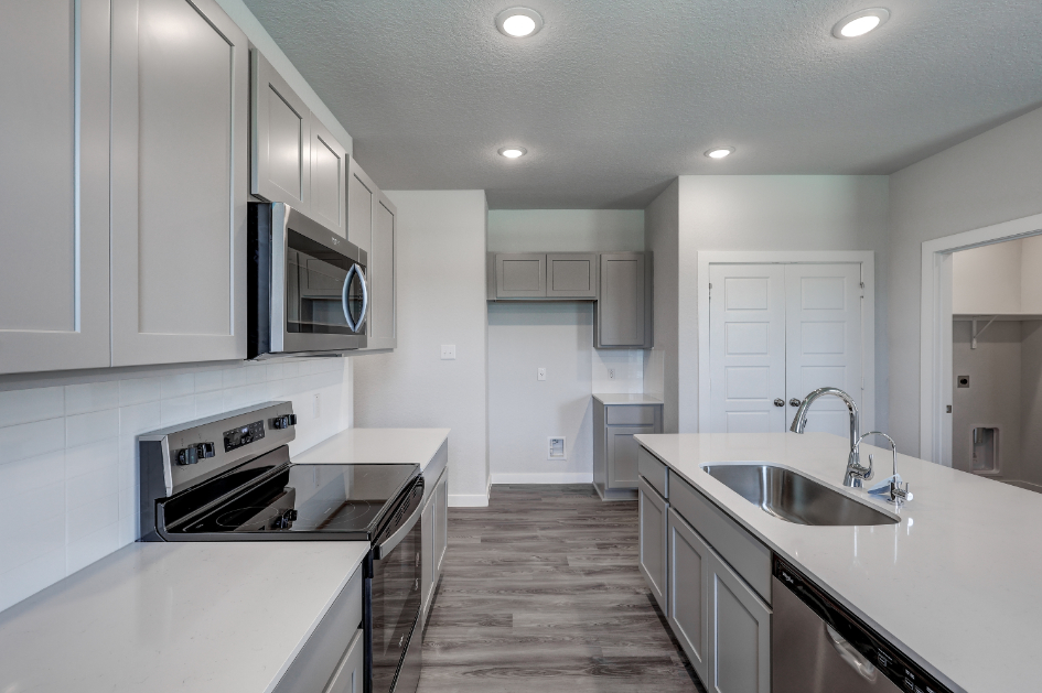 A kitchen with white cabinets.