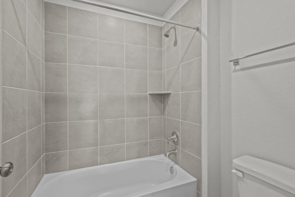 A bathroom with a bathtub and toilet.
