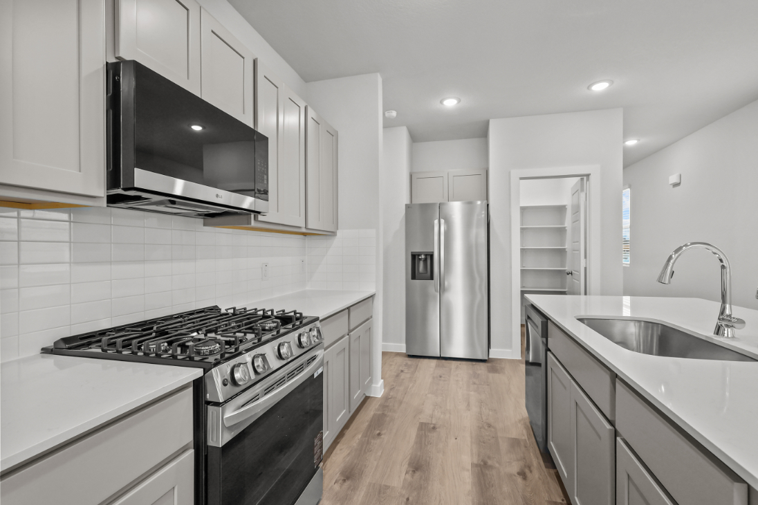 A kitchen with white cabinets.