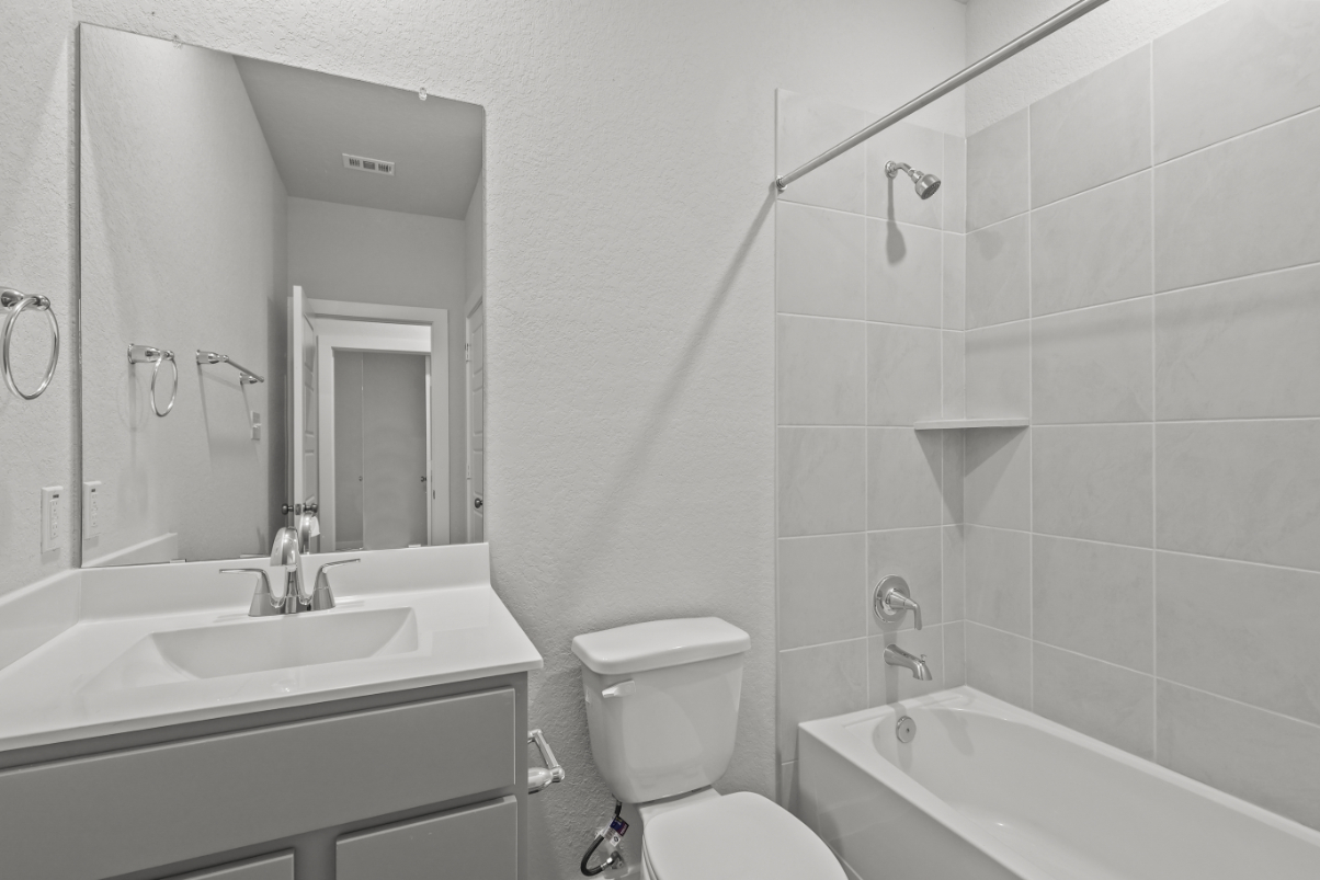 A bathroom with a tub sink and toilet.
